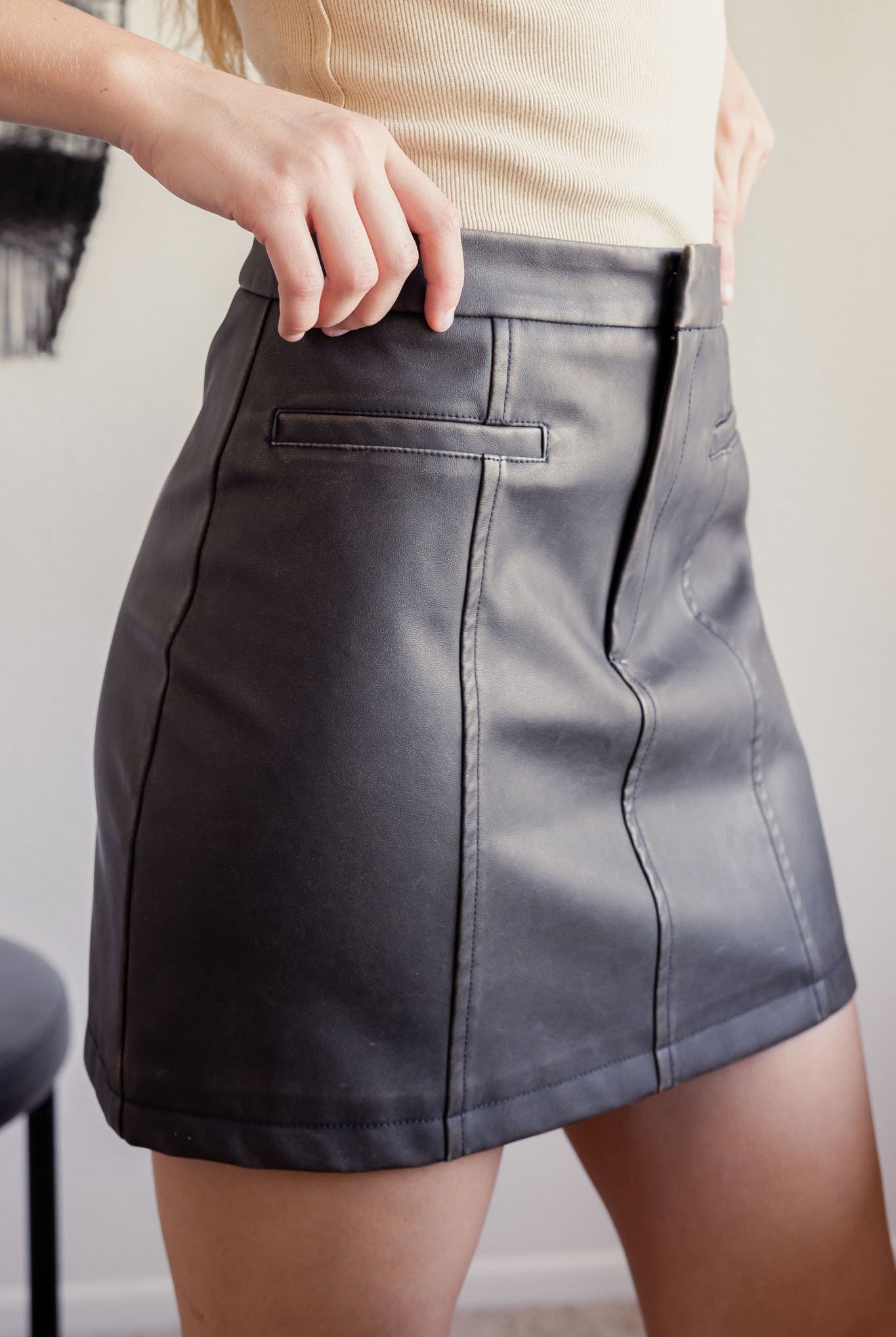 Side view of Washed Vegan Leather Skirt with panel detail and pockets