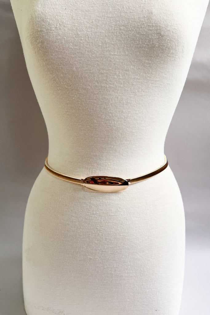 Gold stretch belt with oval buckle styled at the waist