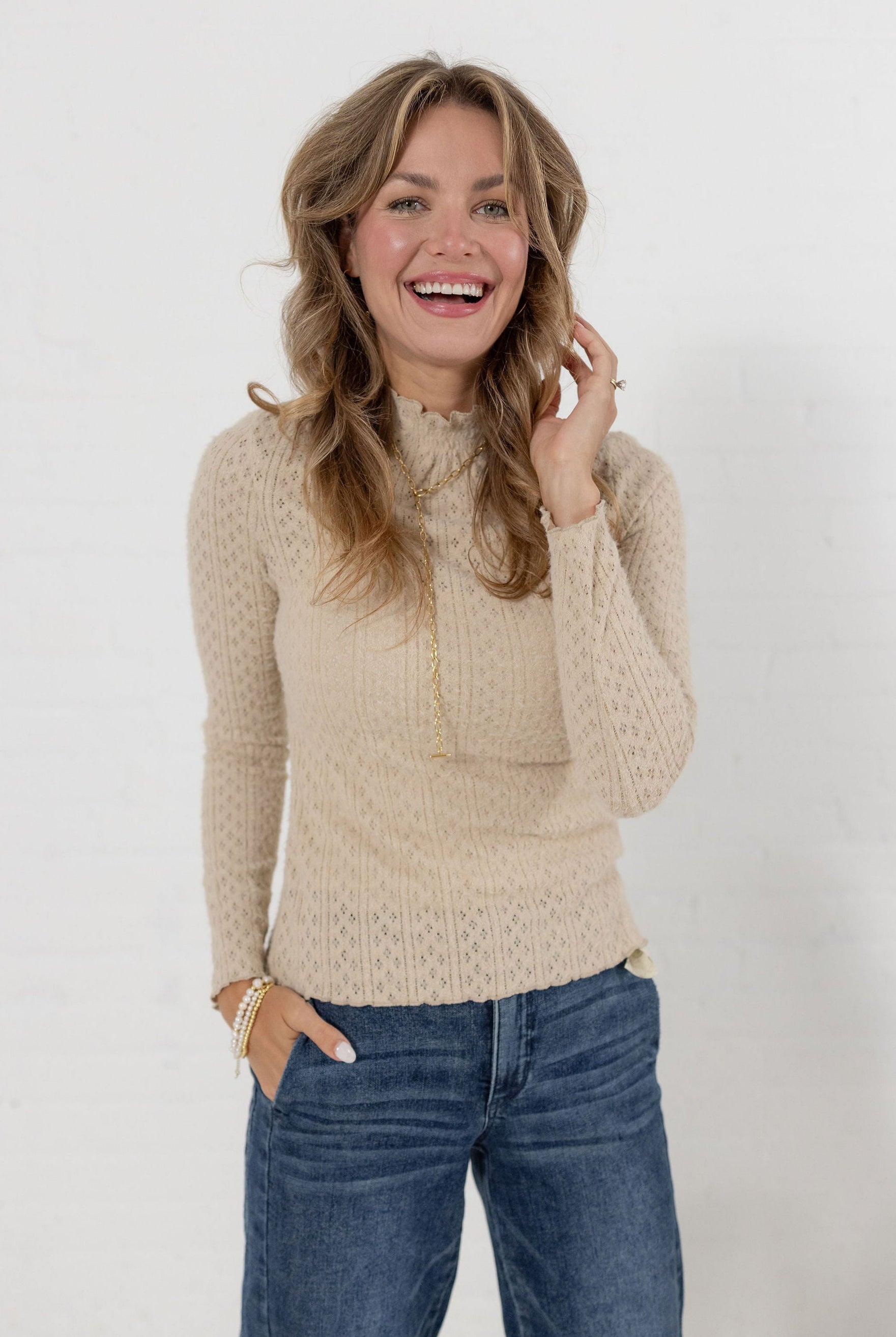 woman modeling the lettuce edge mock neck top in almond color