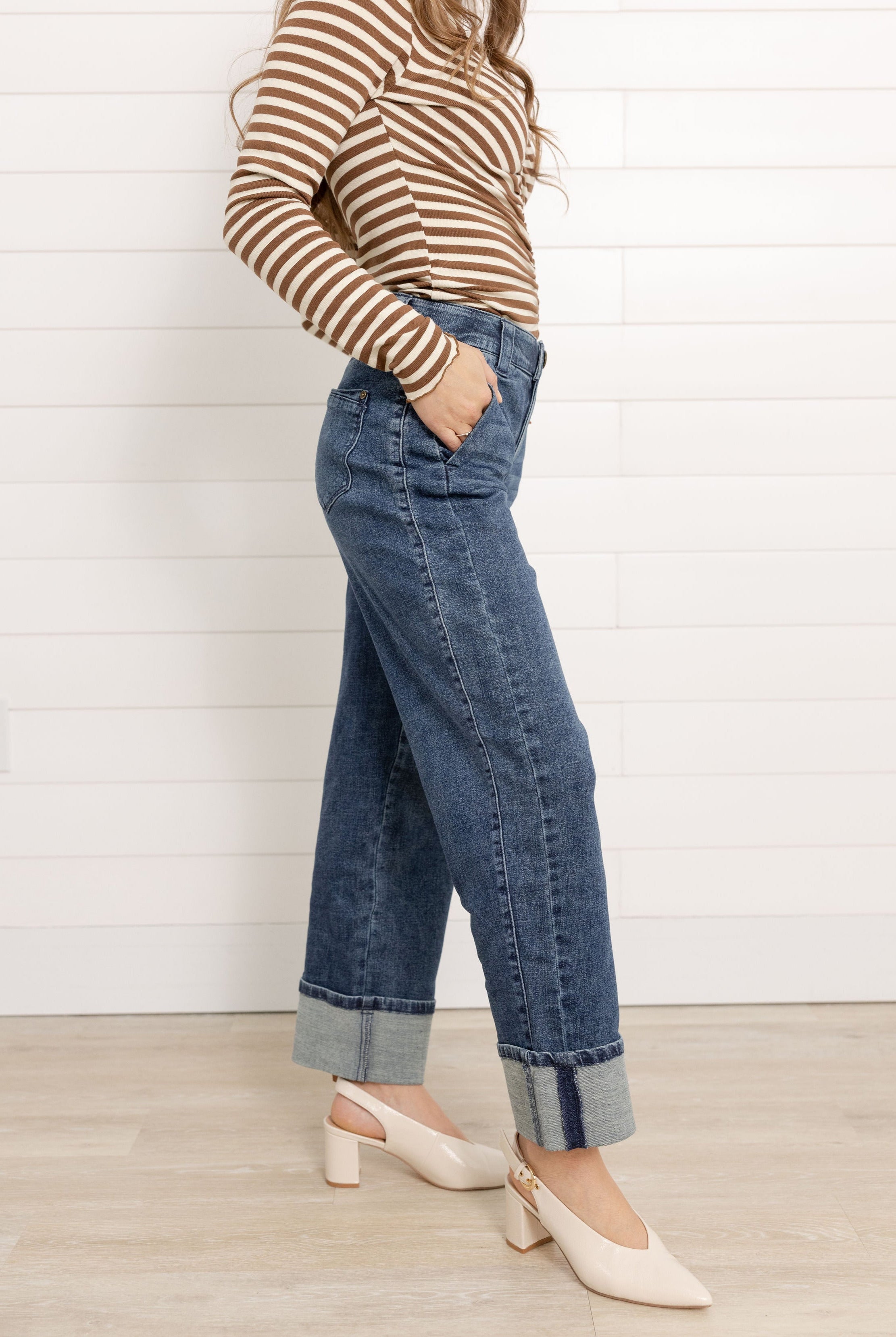 Mac wearing the Mac and Me Boyfriend jean showing the side panel and cuffed bottoms. She is wearing a pair of cream slingback pumps and a striped top.