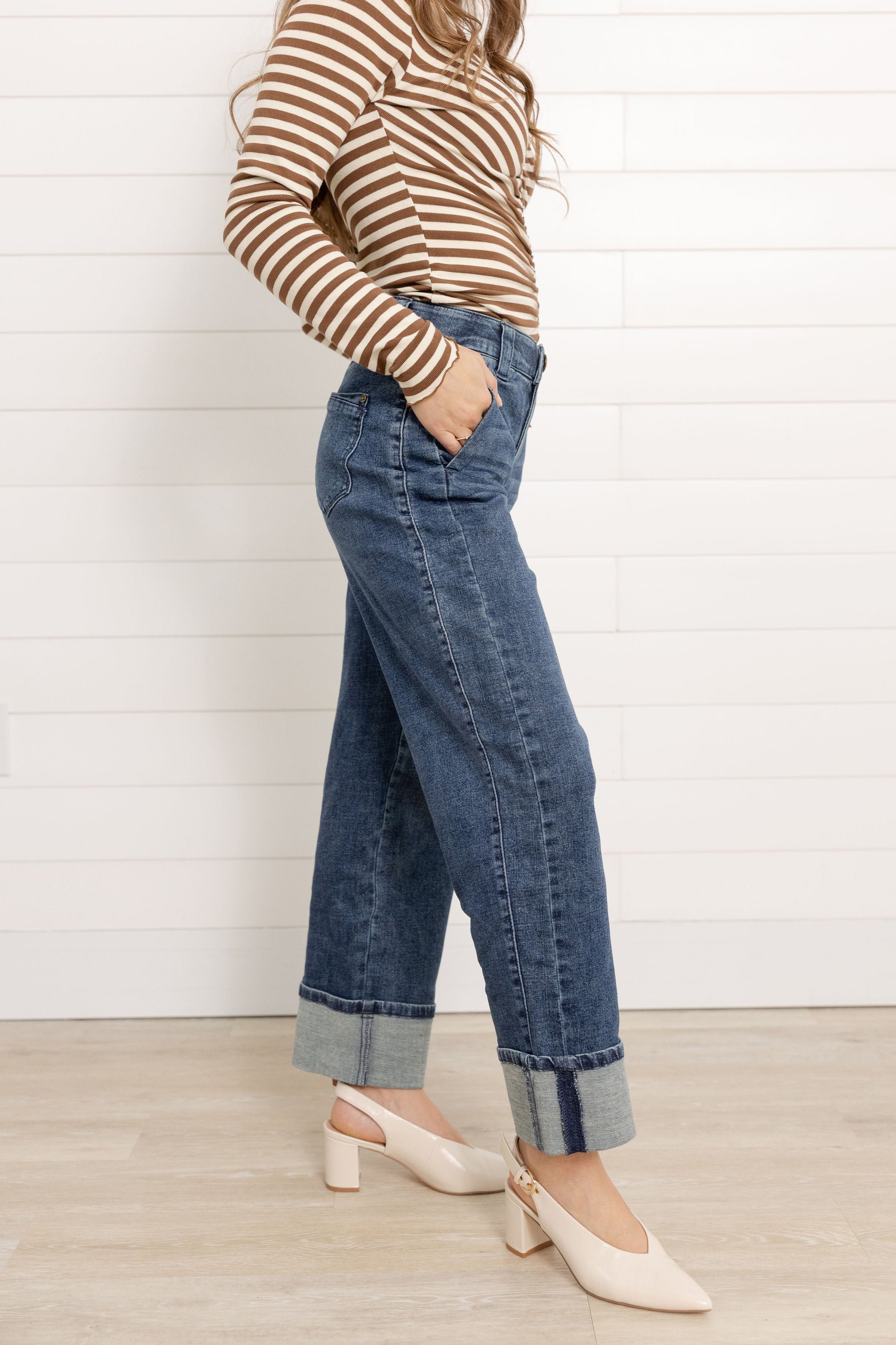 Mac wearing the Mac and Me Boyfriend jean showing the side panel and cuffed bottoms. She is wearing a pair of cream slingback pumps and a striped top.