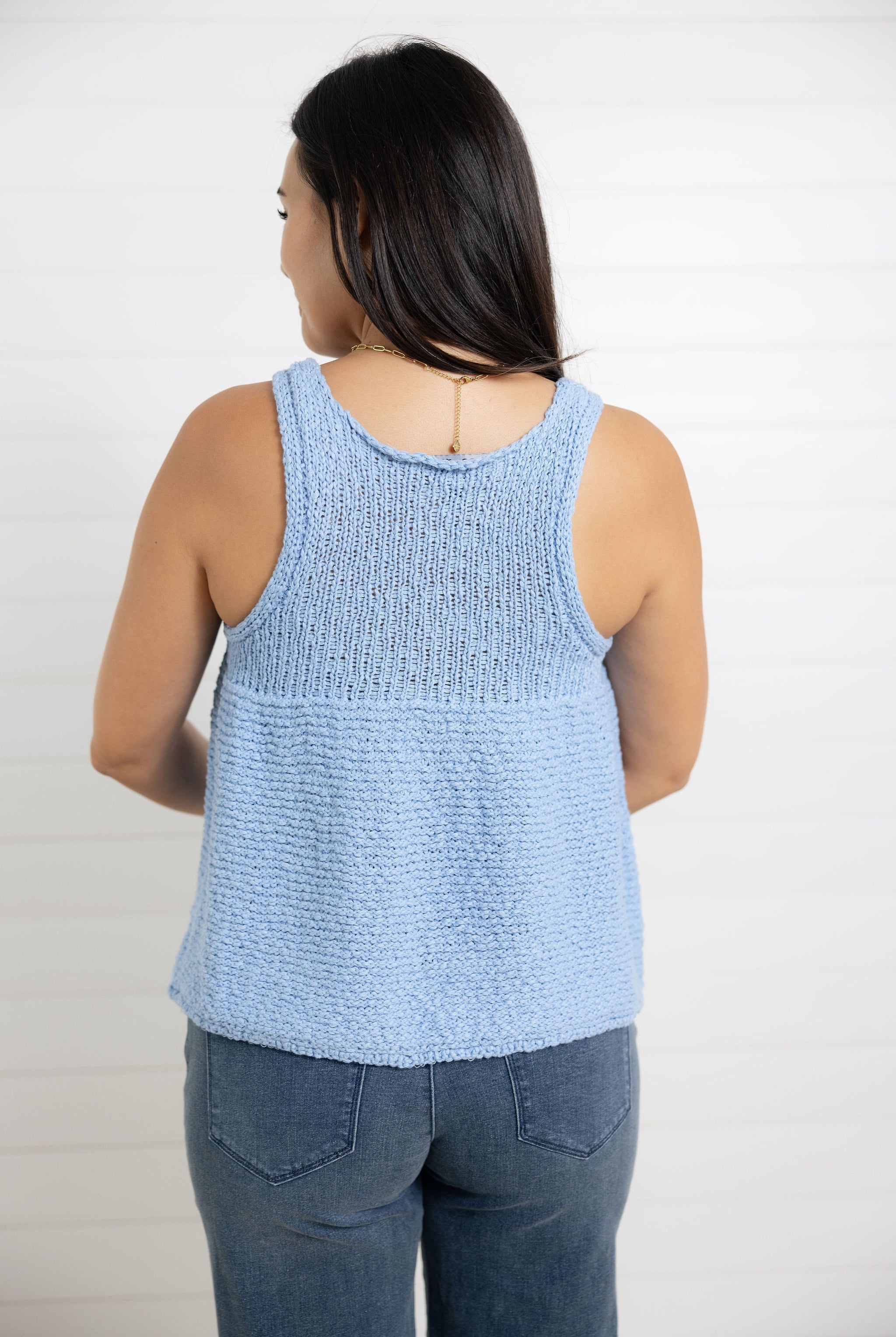 woman modeling the back of mac and me swing sweater top in light blue