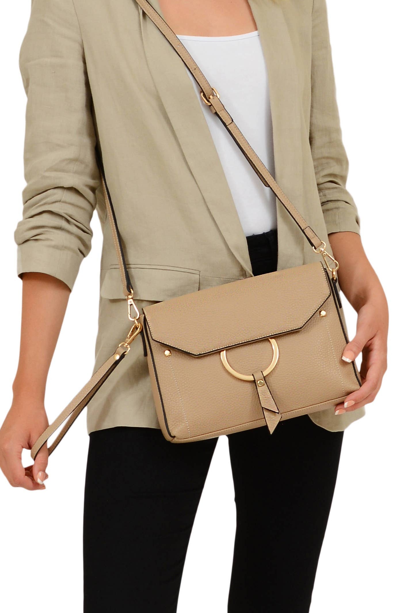 A woman holding the wristlet of the Portia Crossbody as well as the adjustable shoulder strap on the purse