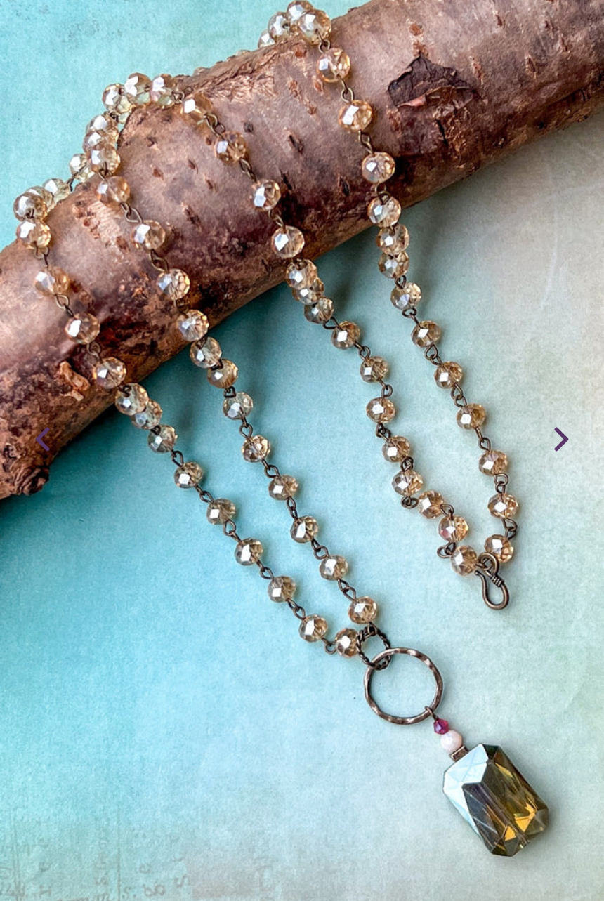 Necklace with beads and a pendant on a textured surface