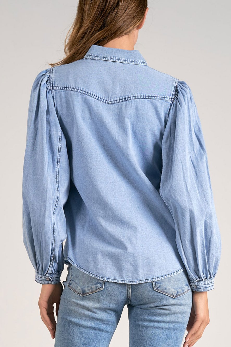 Model showing the back of the classic long sleeve cotton button down top with puff sleeves from Mainstream Boutique Bloomington, styled for fall.