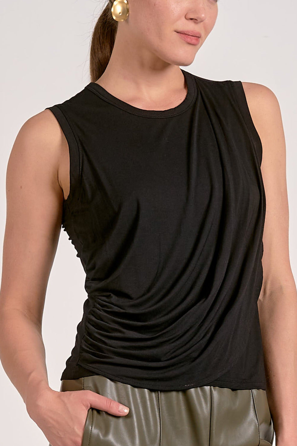 Close up view of black draped sleeveless top with flattering side drape and lightweight knit