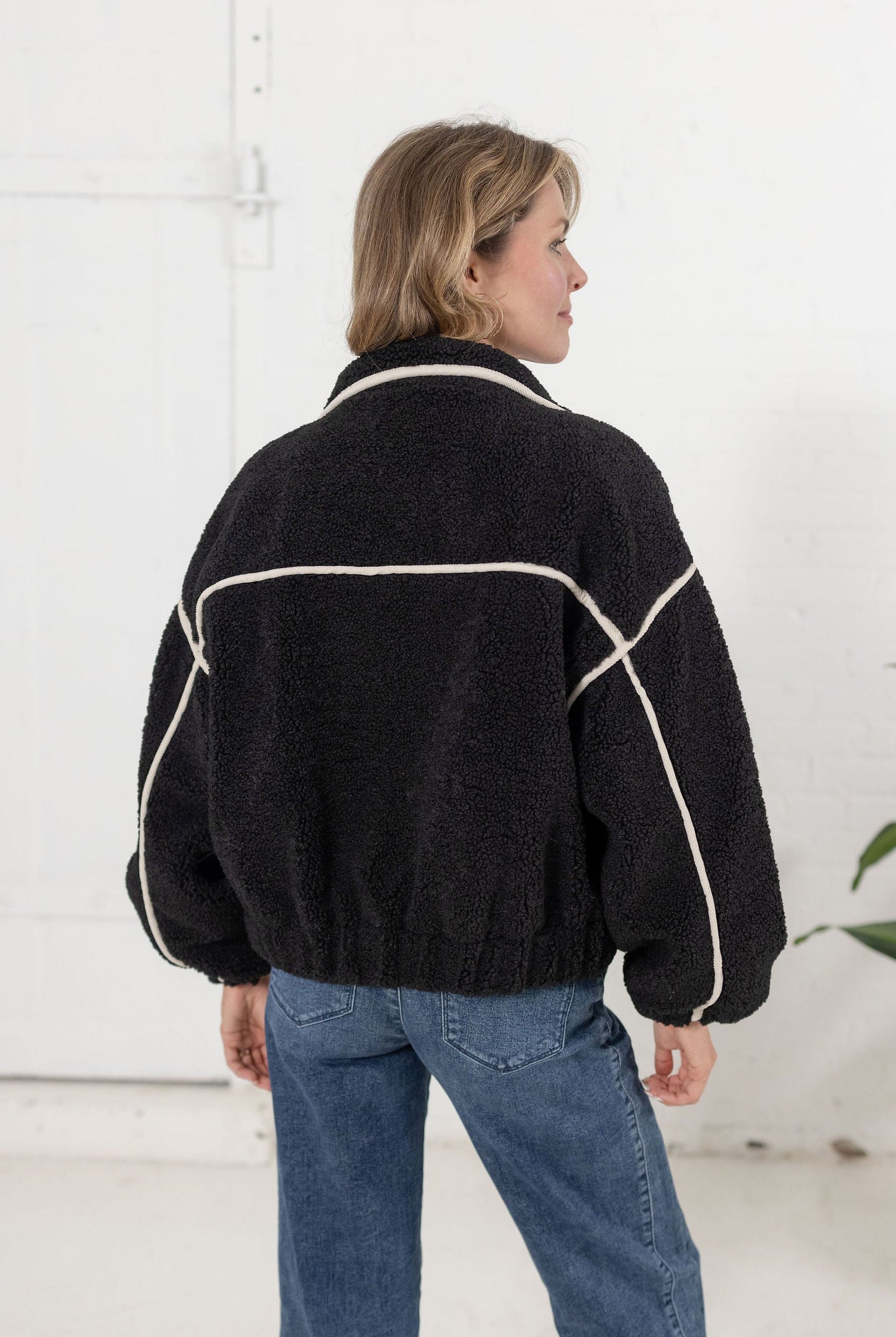 back of the black sherpa bomber jacket showing the off white corduroy detailing throughout.
