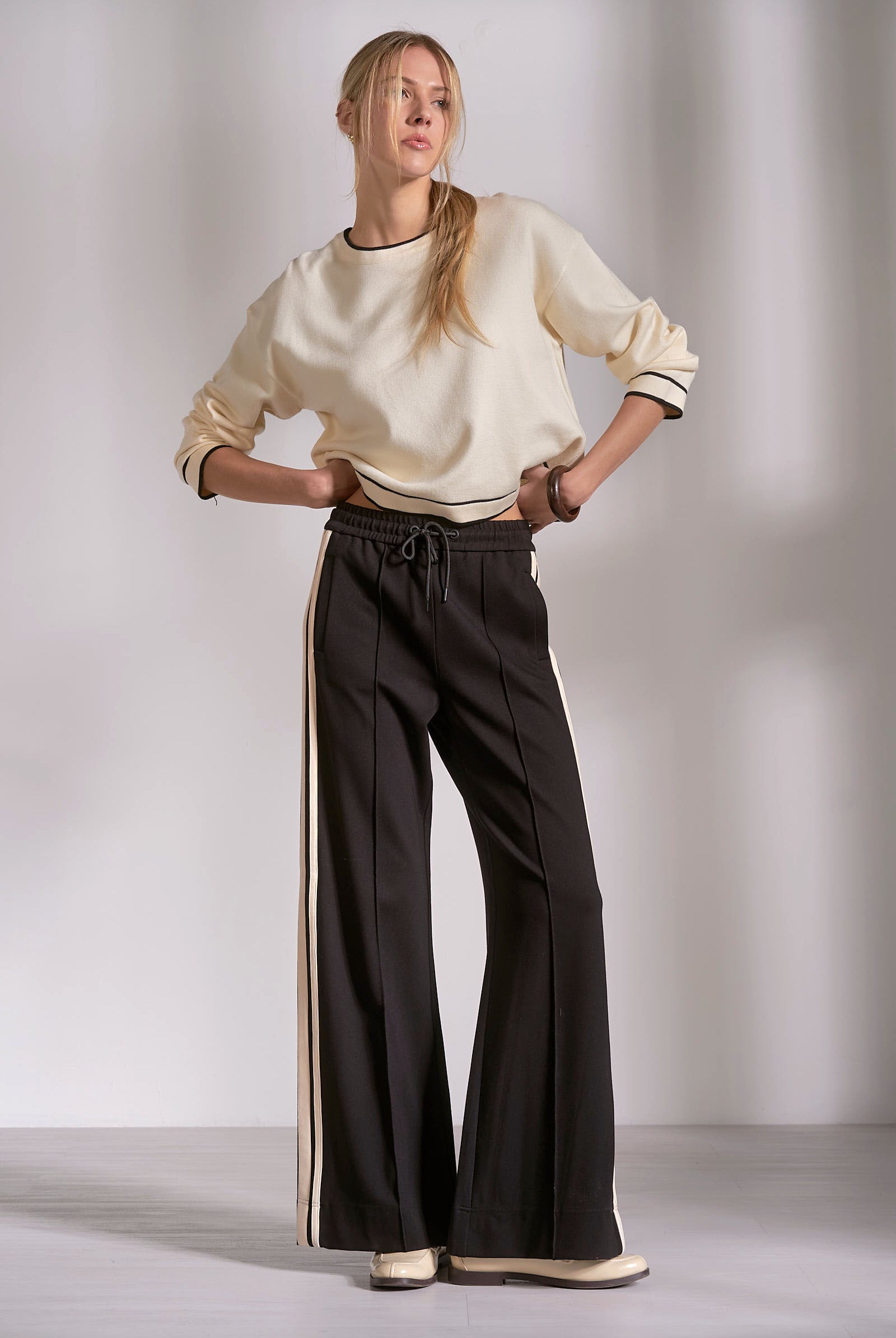 Elevated black track pants with contrast stripe and relaxed fit