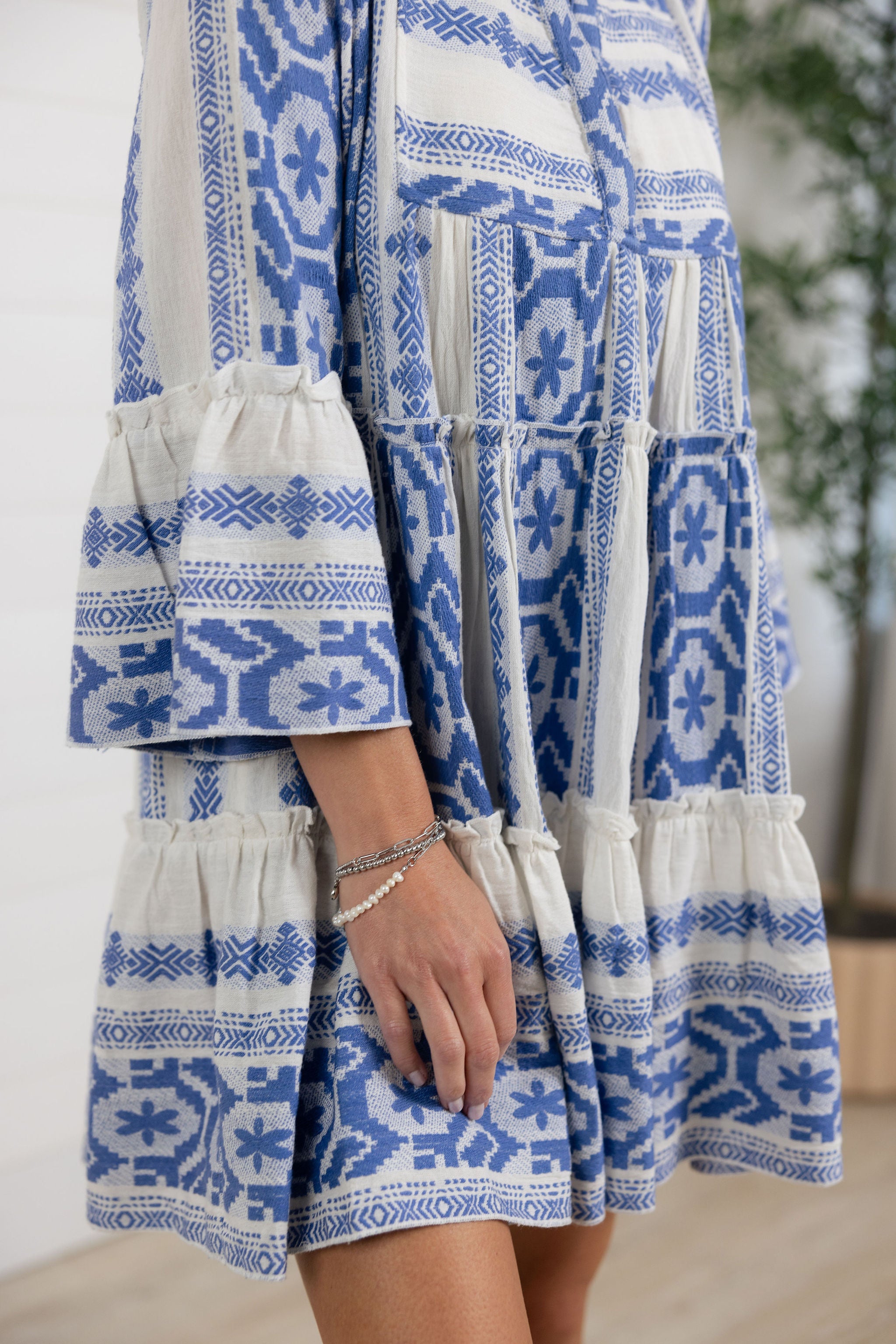 details on blue tiered mini dress with bell sleeves