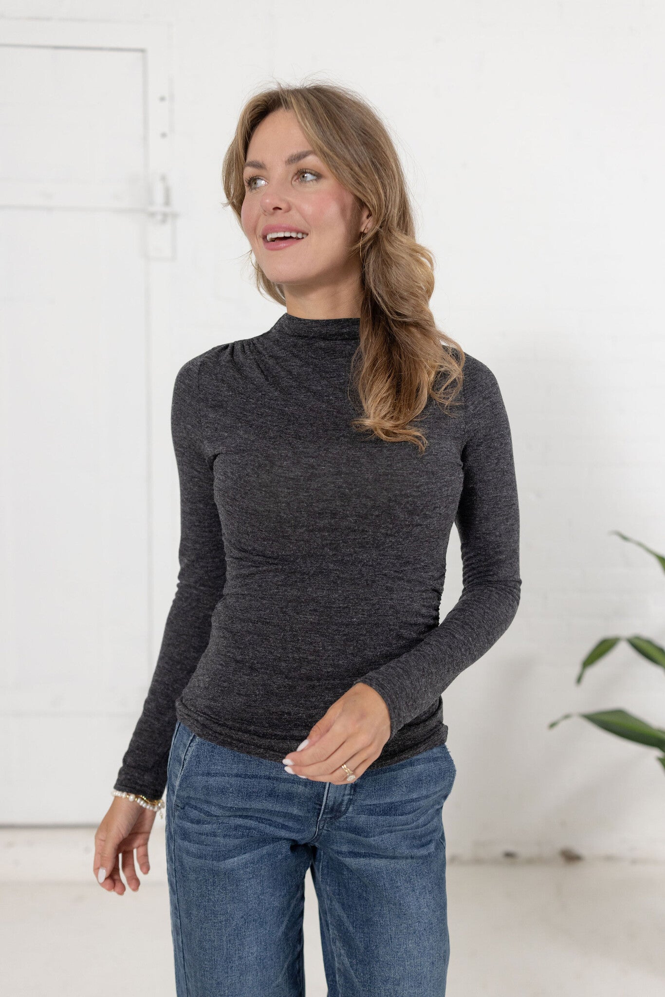 woman modeling Mock Neck Side Ruched Top in brushed grey with Mac and Me jeans.
