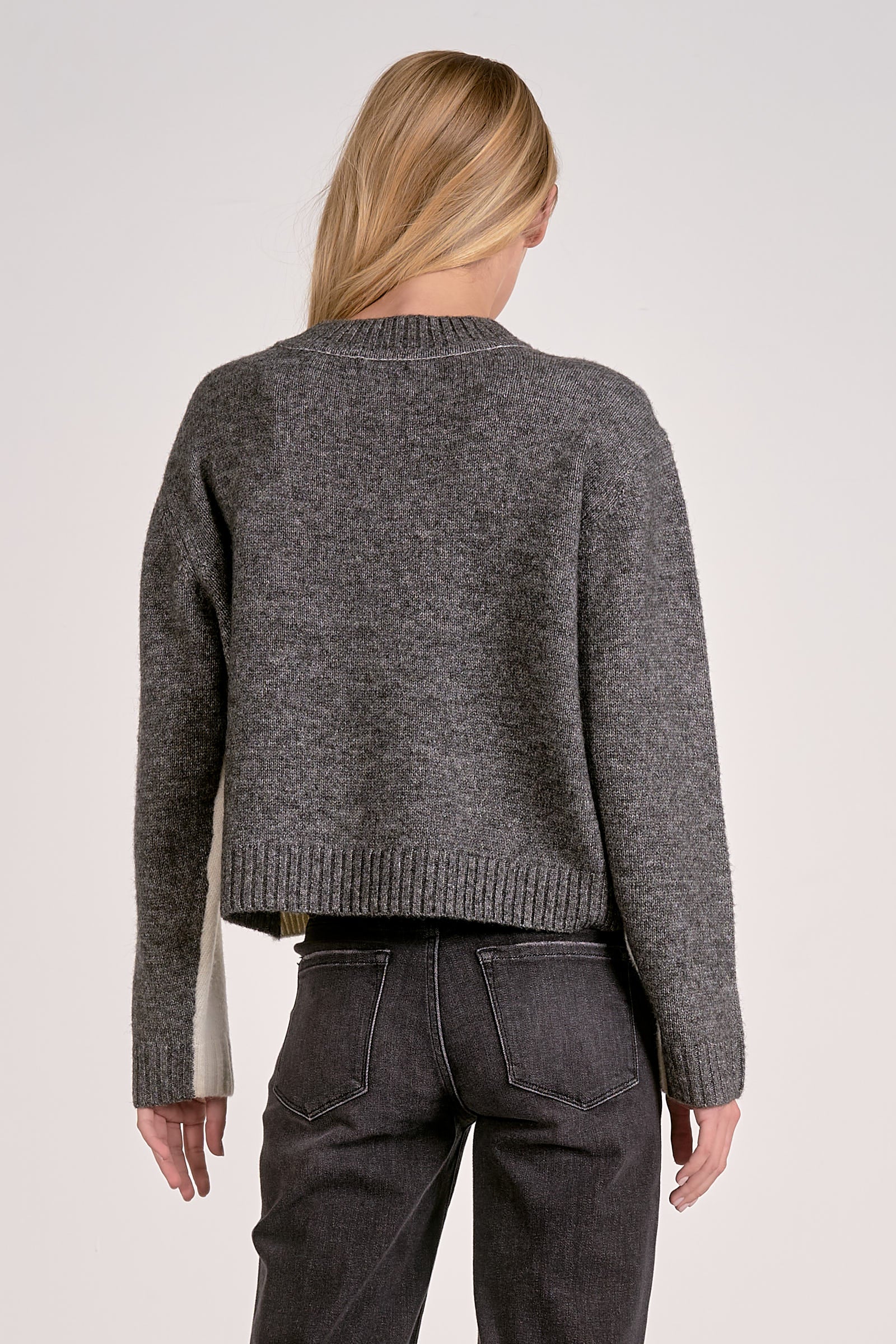 Back view of white and grey color block crewneck sweater with soft knit and stripe sleeve effect