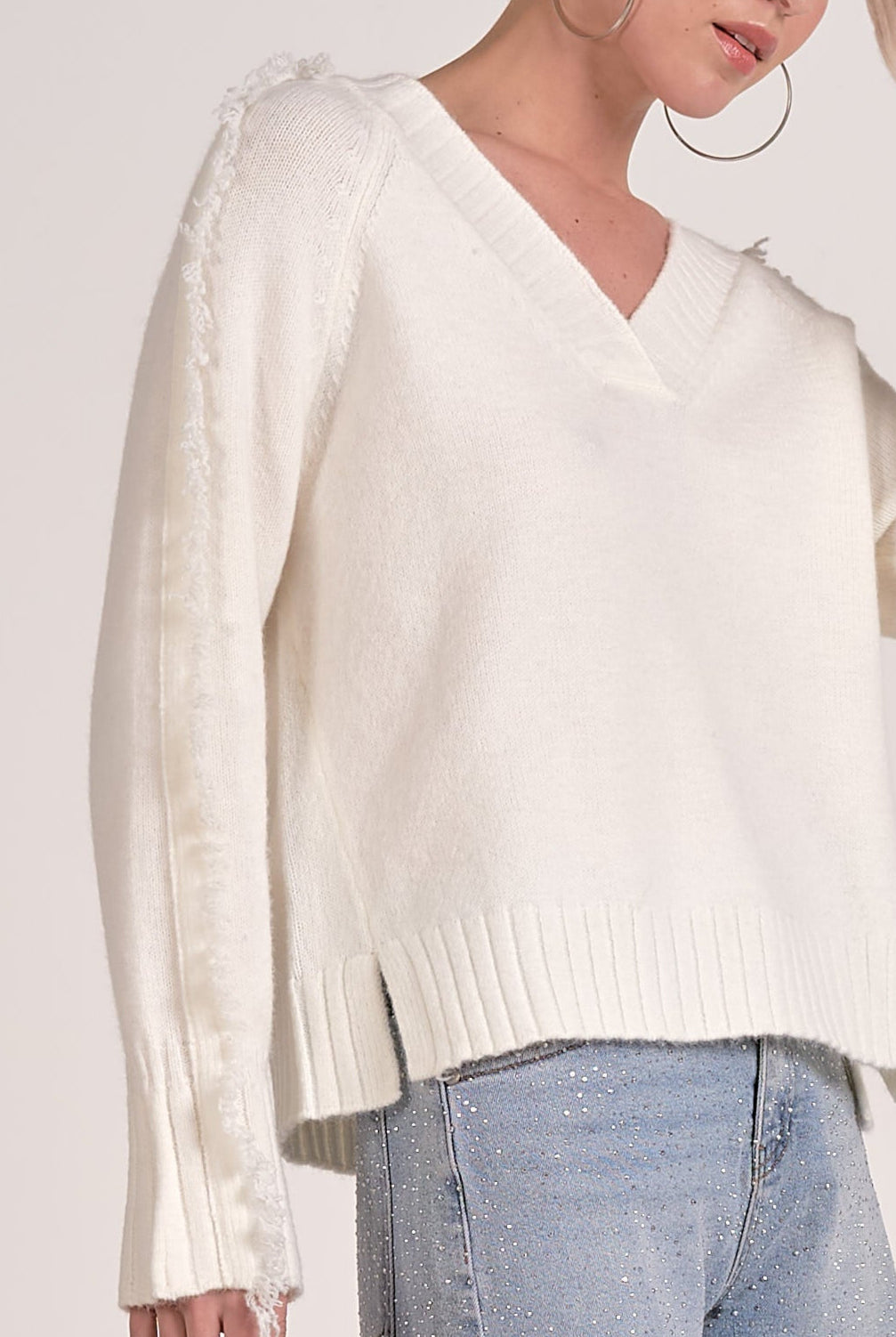 details on the Willow Fringe V-Neck Sweater in ivory white fringe trim sleeves from Mainstream Boutique Bloomington