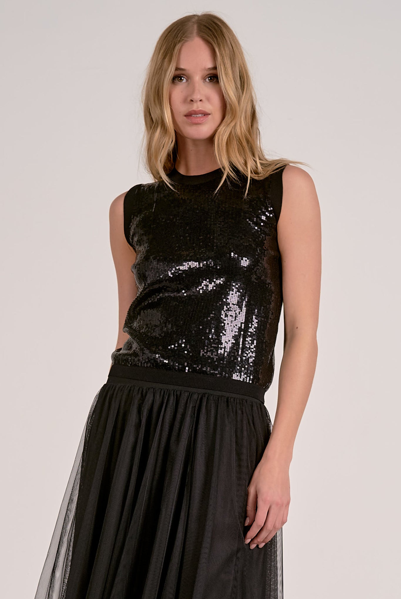 Model wearing black Glitter Tank Top with sequin finish and sleeveless silhouette from Mainstream Boutique Bloomington
