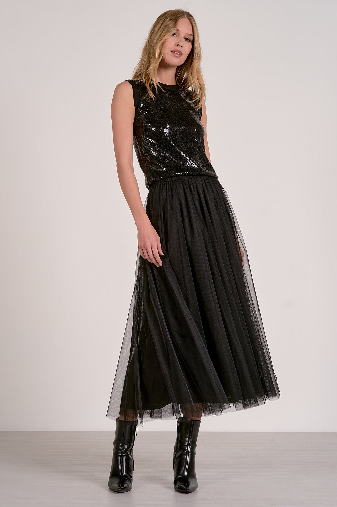 Woman modeling the black sequin glitter tank top and tulle skirt from Mainstream Boutique Bloomington