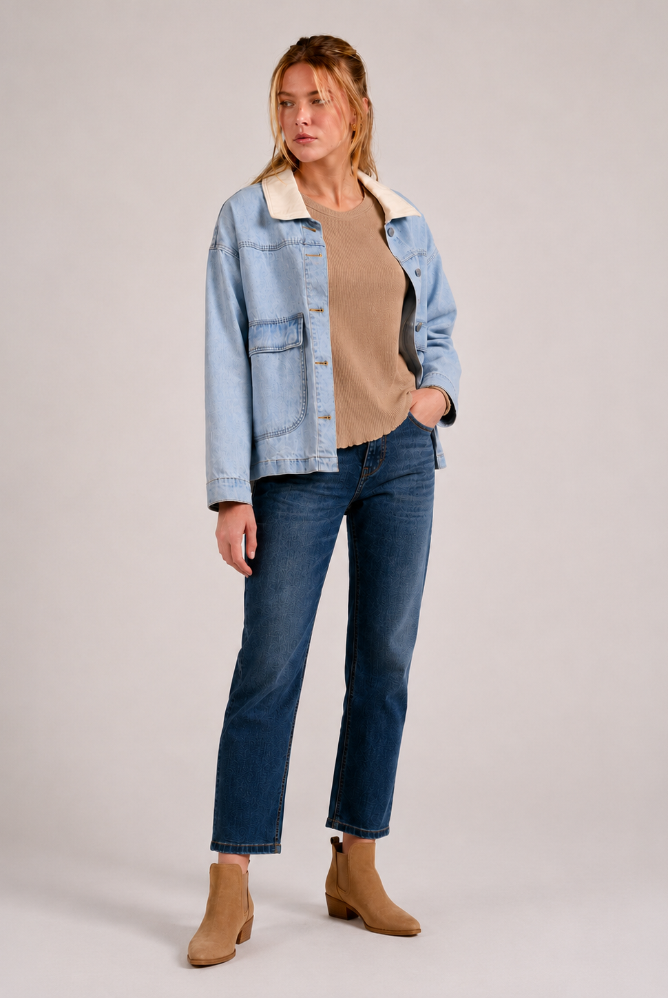 woman modeling light blue denim jacket, with cream contrast collar, tan waffle knit top, and darker jeans with tan booties