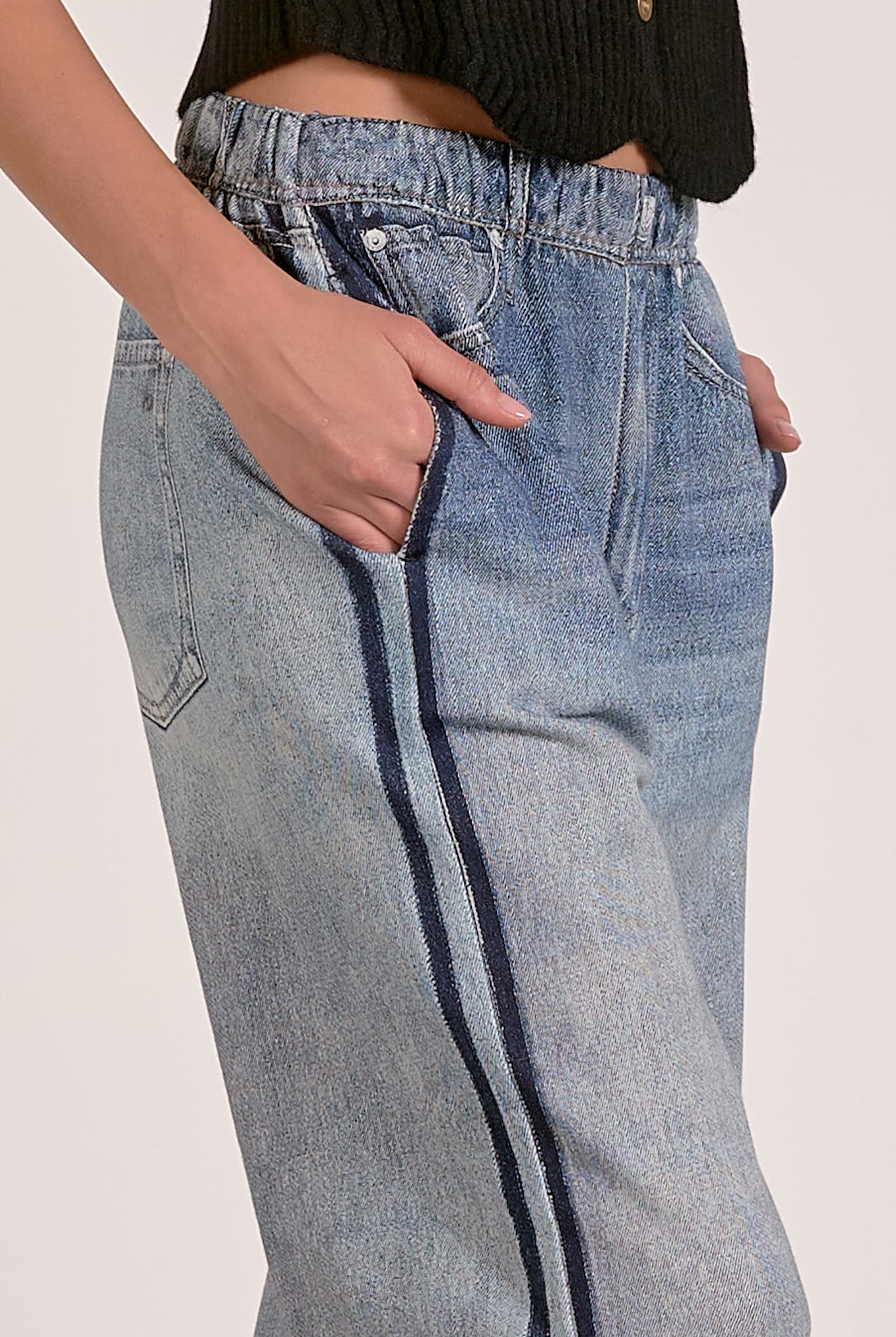 Light blue jeans with a dark stripe on a plain background