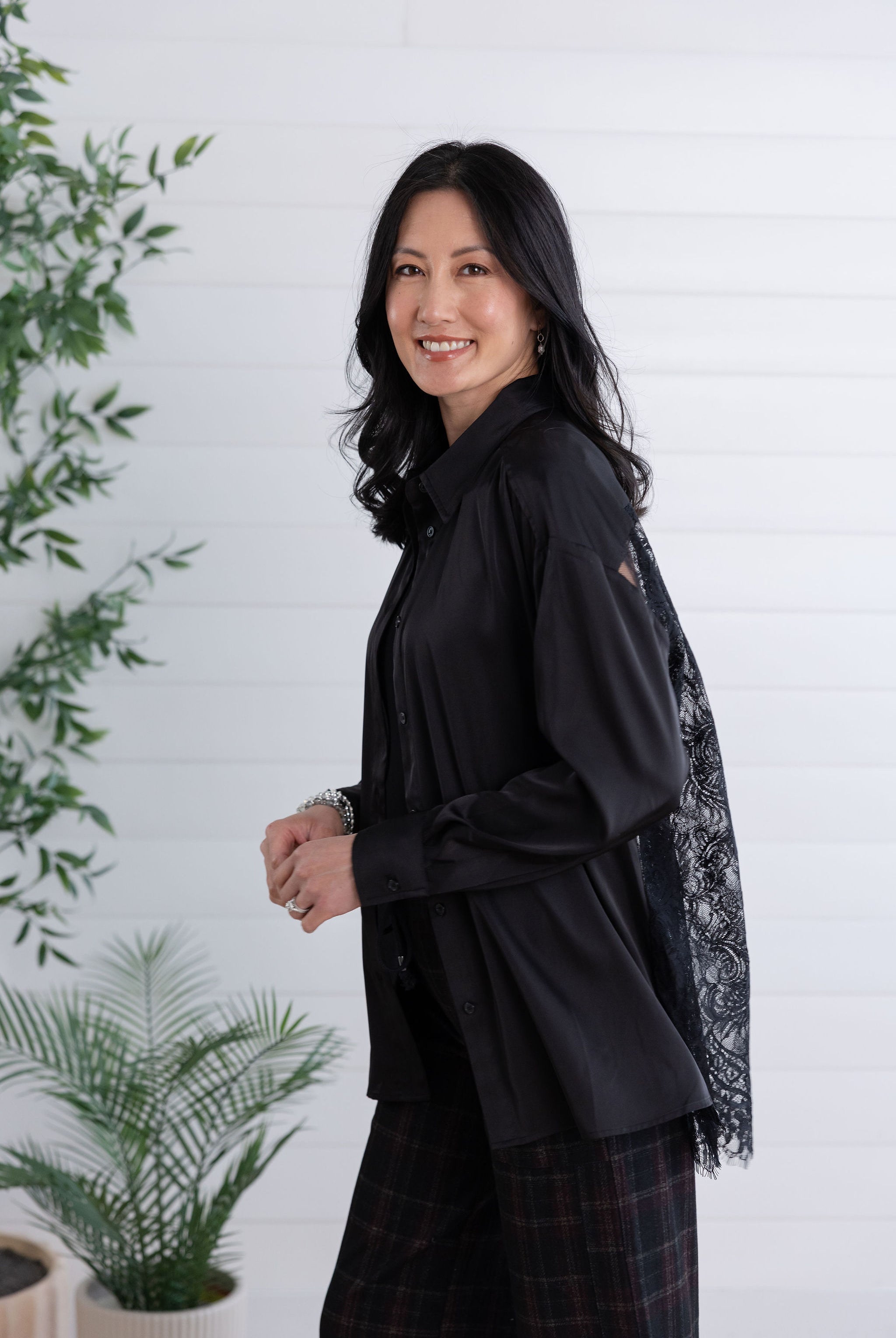 flowy movement on model of the black lace back button down showing sleek front side and lace back
