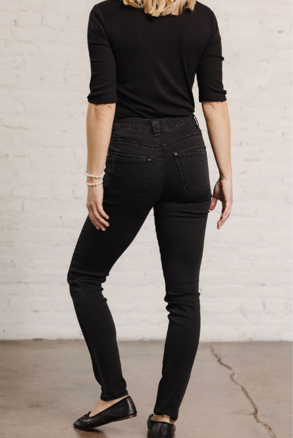 Woman showing the back of the Mac and Me black denim