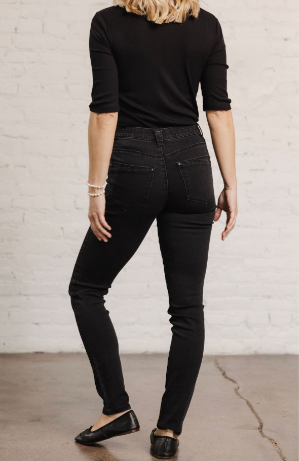 Woman showing the back of the Mac and Me black denim
