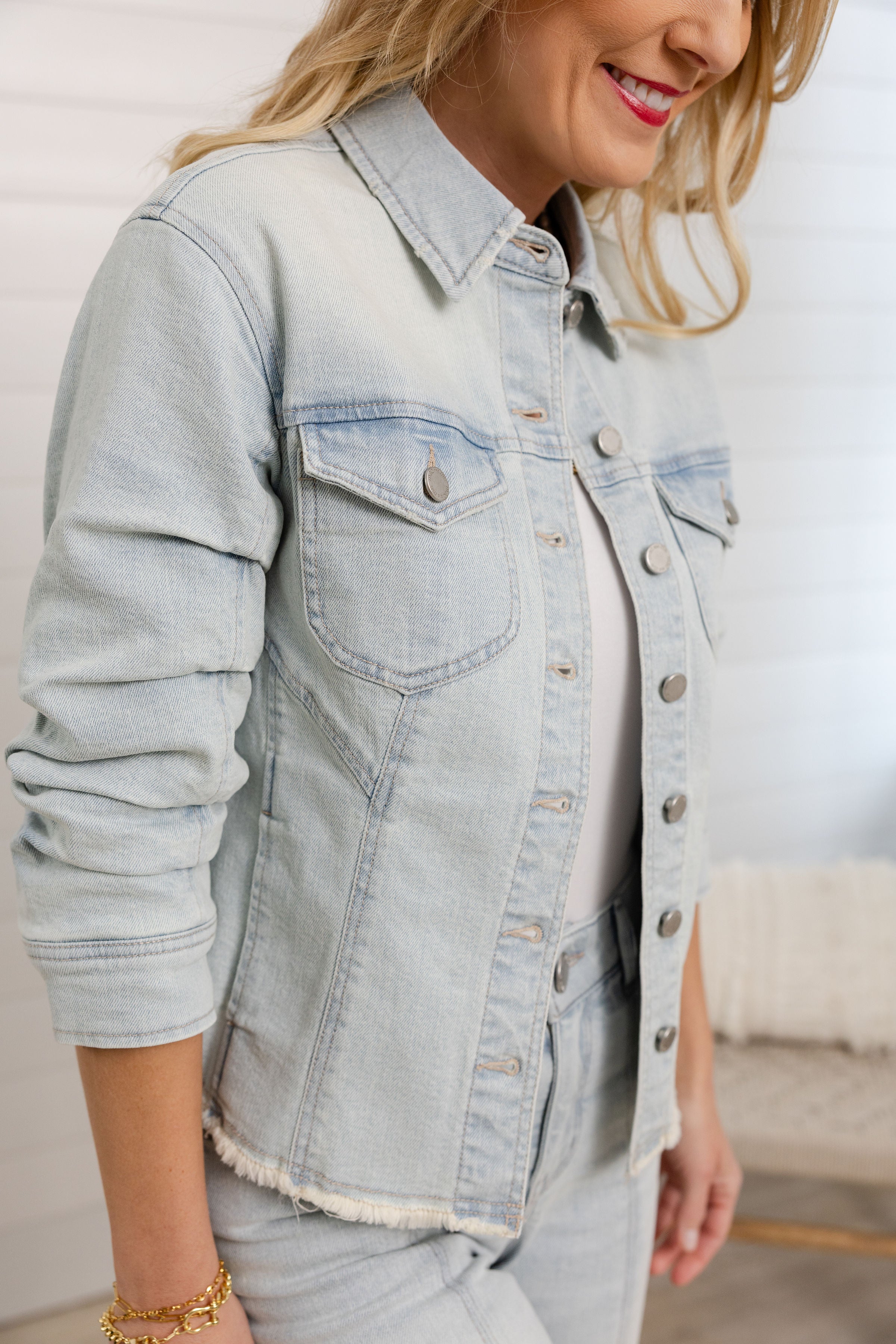 closeup of Mac and Me bleached blue ruched sleeve denim jacket with fray hem