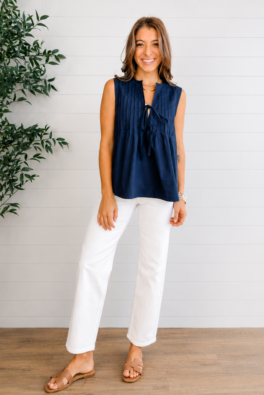 woman wearing sleeveless navy tie-front top with white denim