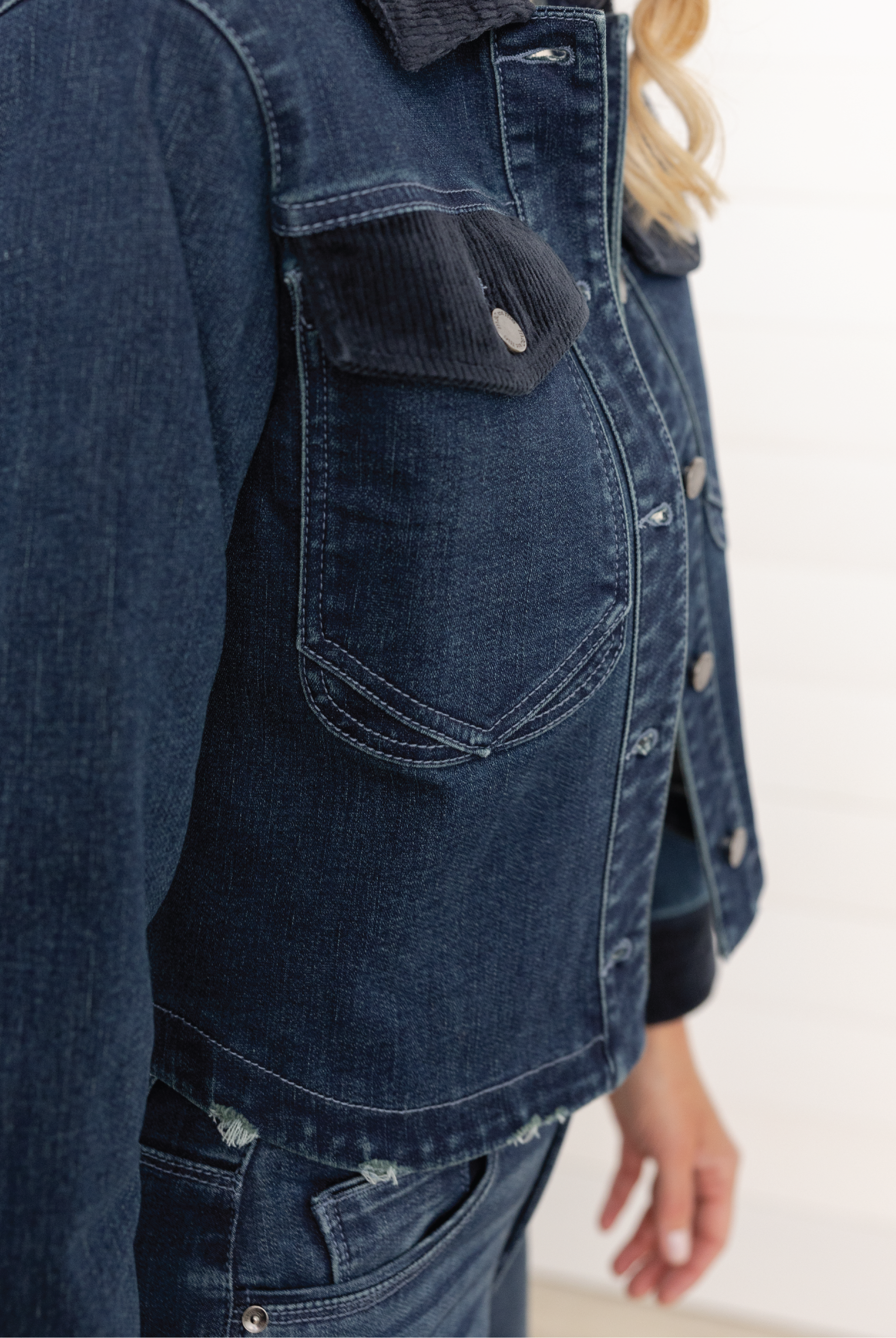 Close-up of a woman wearing Mac and Me oversized indigo denim jacket with corduroy collar and flap pockets