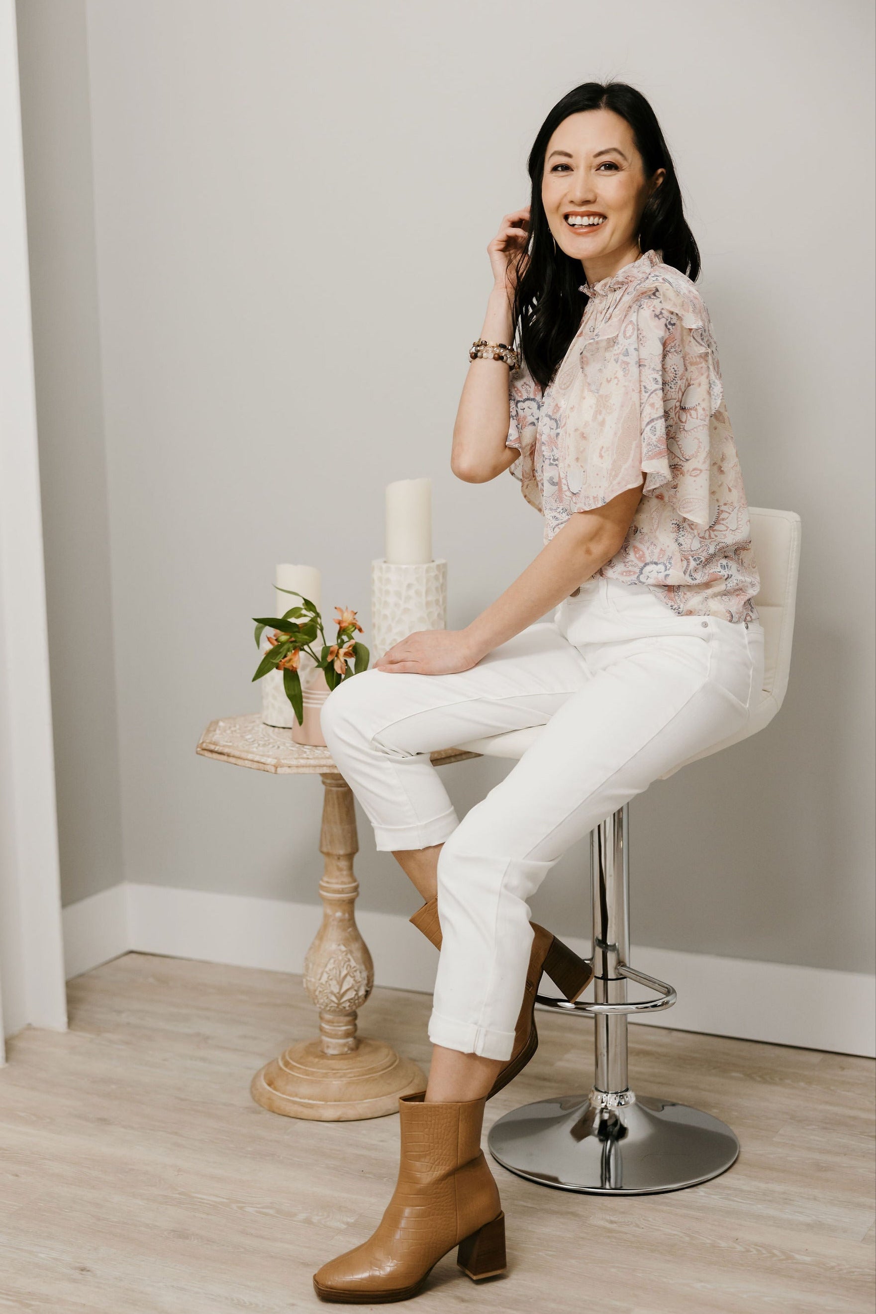 White girlfriend jeans styled with booties, and a transitional top