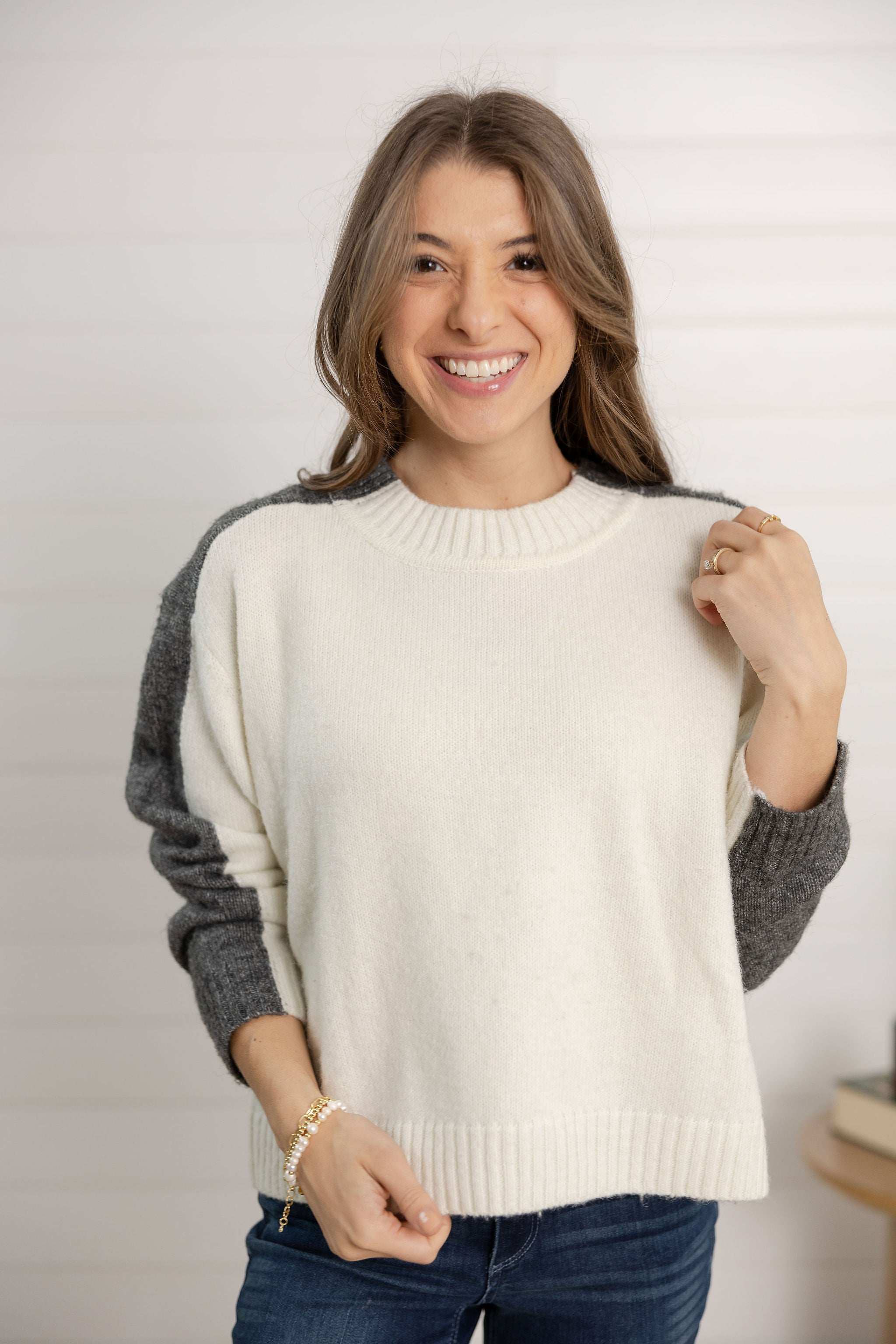 woman showing the color block sweater front side with sleeves pushed back