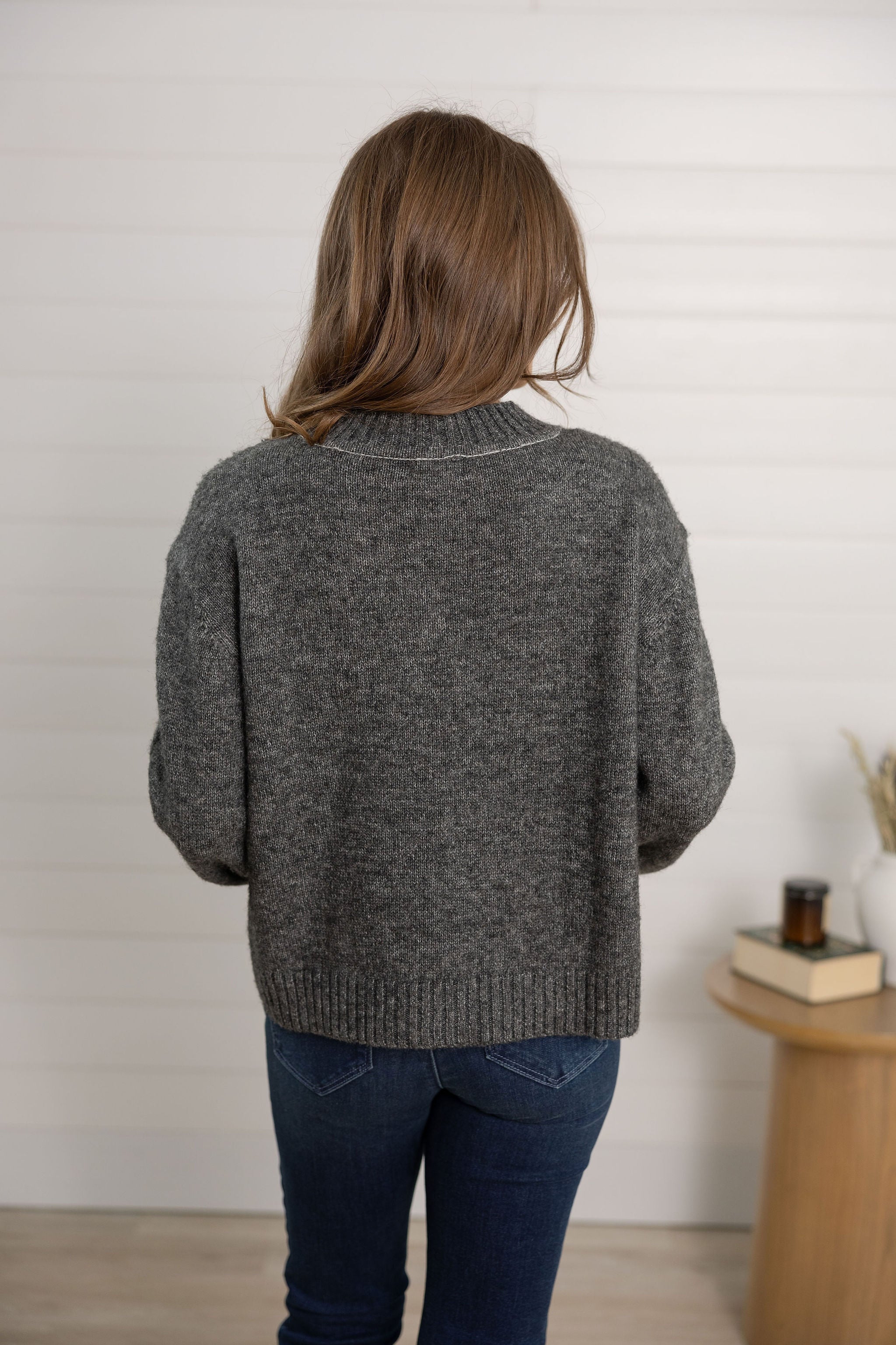 woman showing the back of the sweater as grey in the color block design