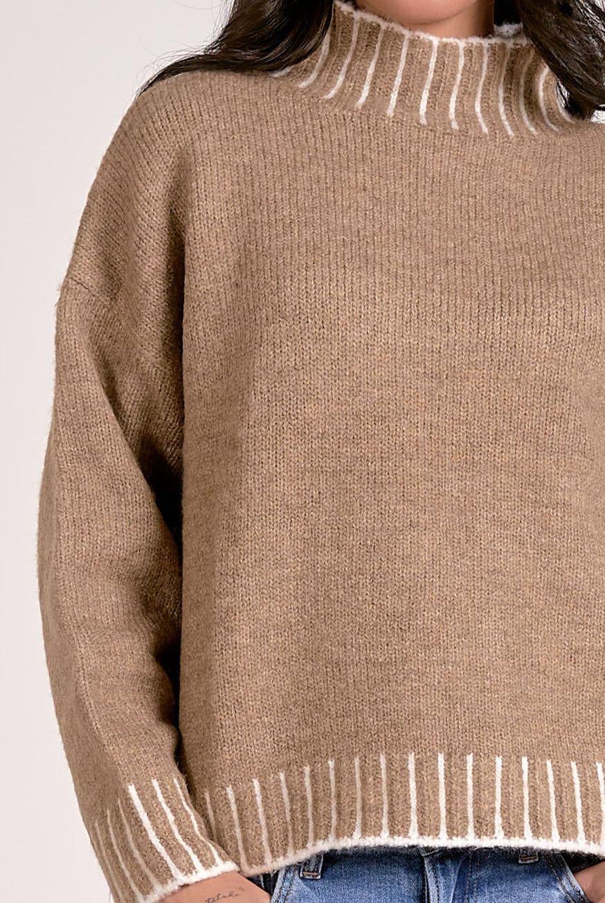 details of tan mock neck sweater with white whipstitch