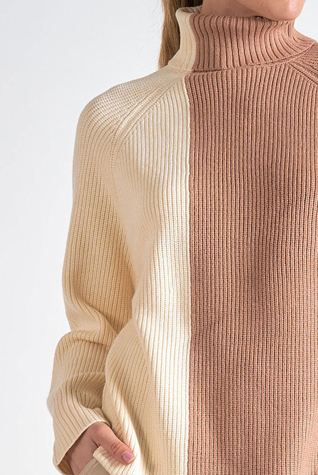 A woman showing the details on the colorblock sweater with creamy ivory and soft beige vertical blocks