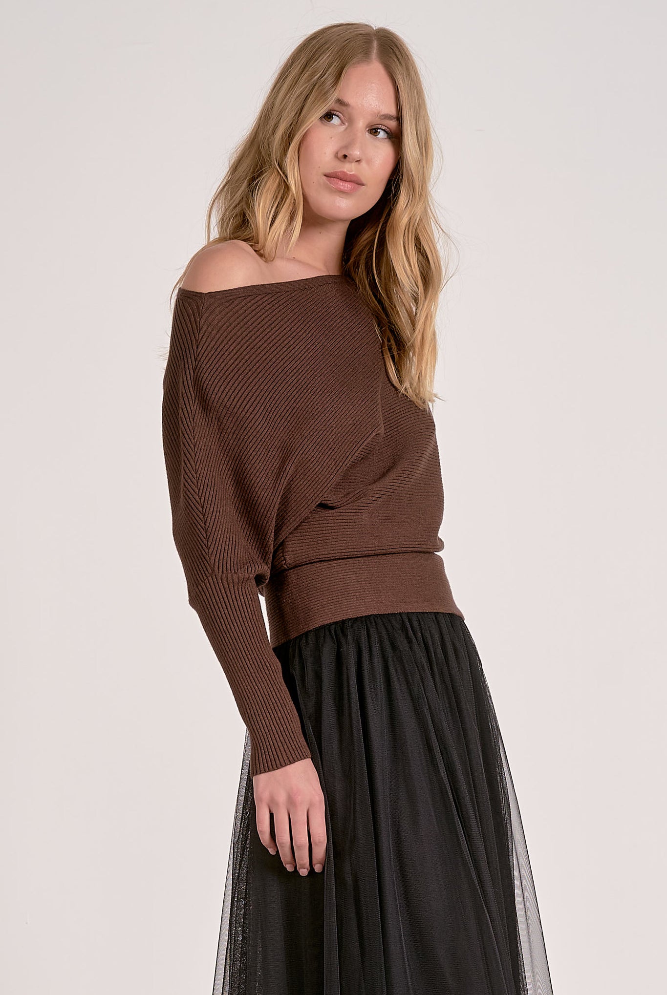 model wearing dark chocolate off shoulder ribbed sweater with dolman sleeves