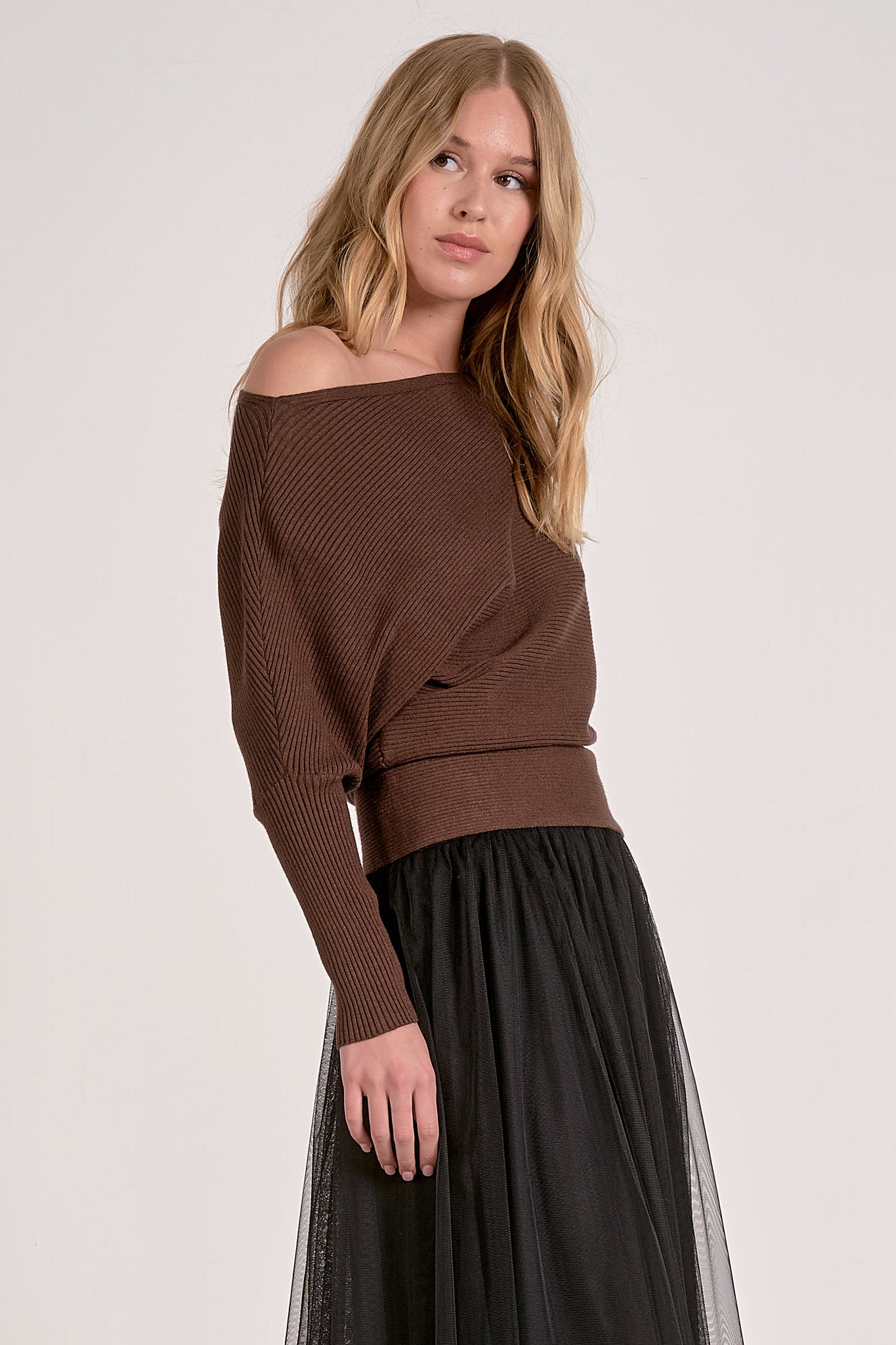 model wearing dark chocolate off shoulder ribbed sweater with dolman sleeves