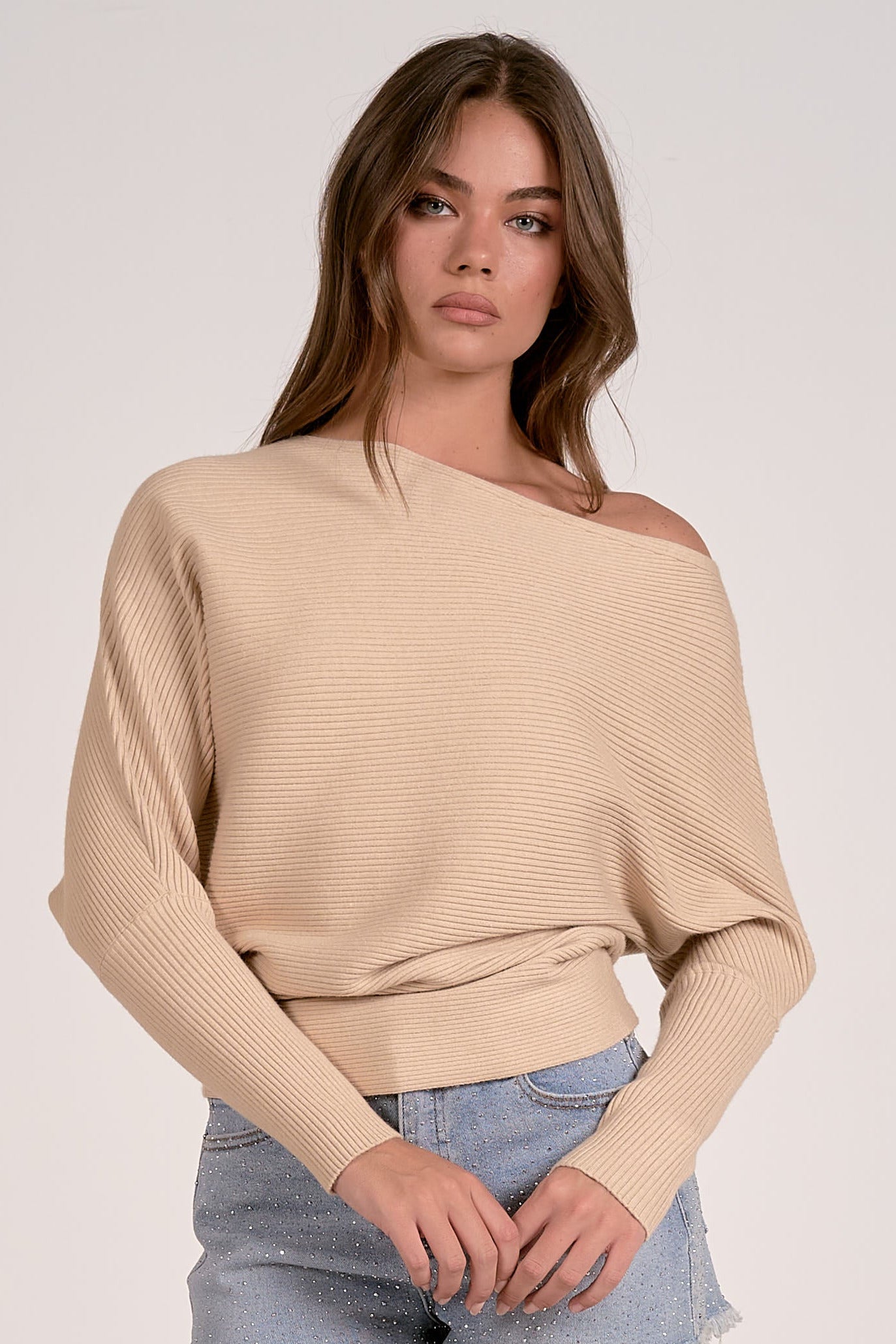sand color off shoulder ribbed sweater styled with denim shorts