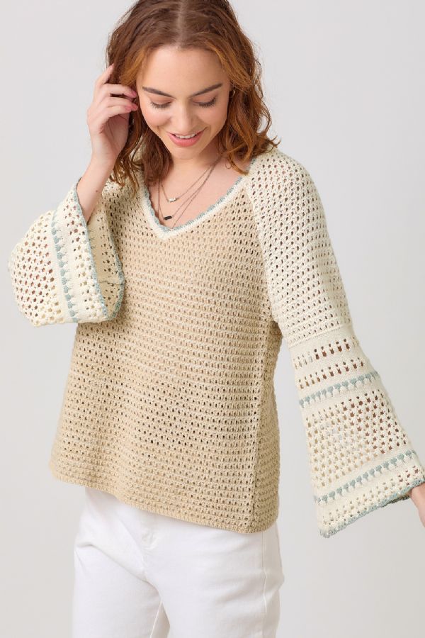 woman wearing a crochet sweater top in neutrals and a v neck on sale