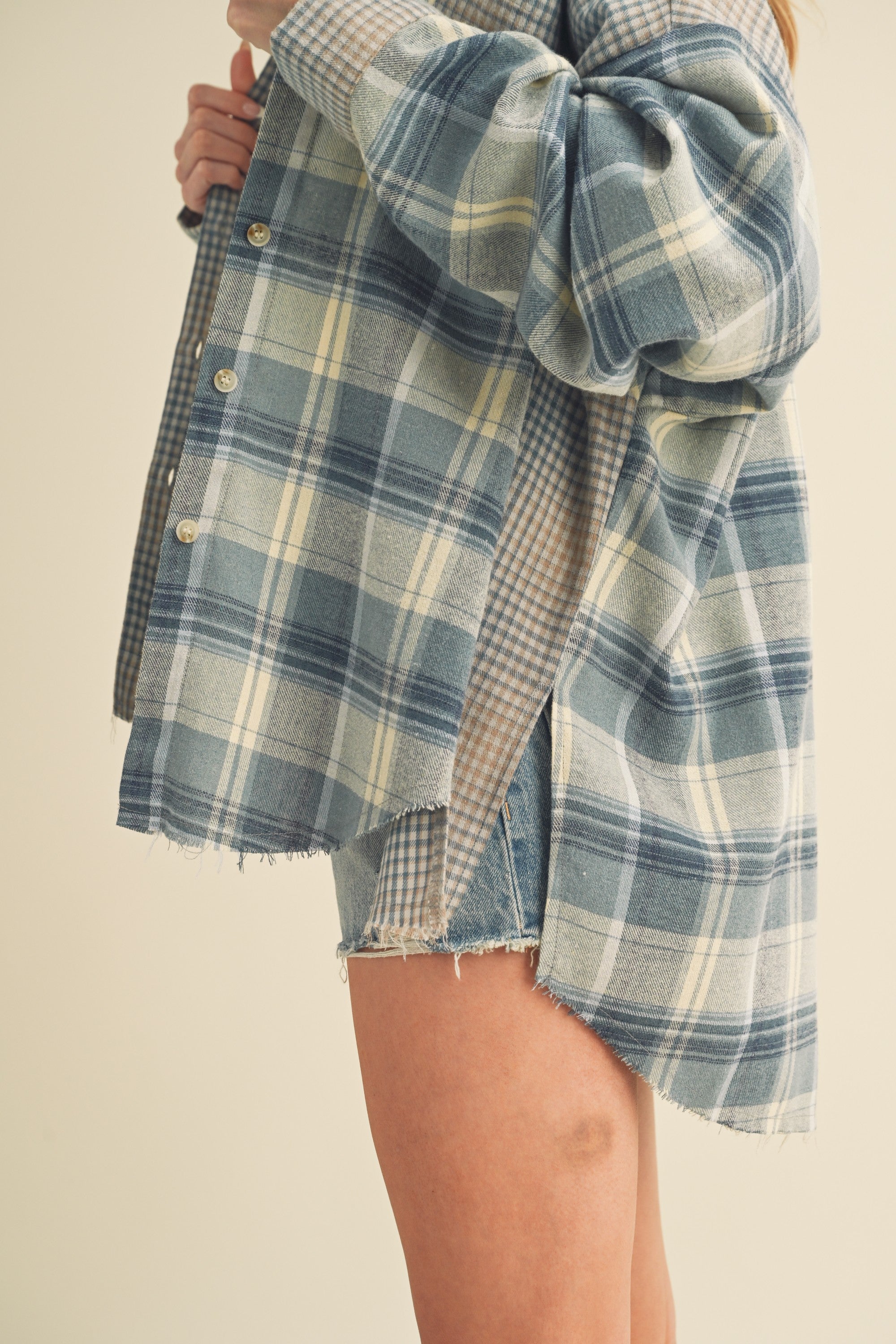 close up of Plaid shirt over a checkered dress on a plain background