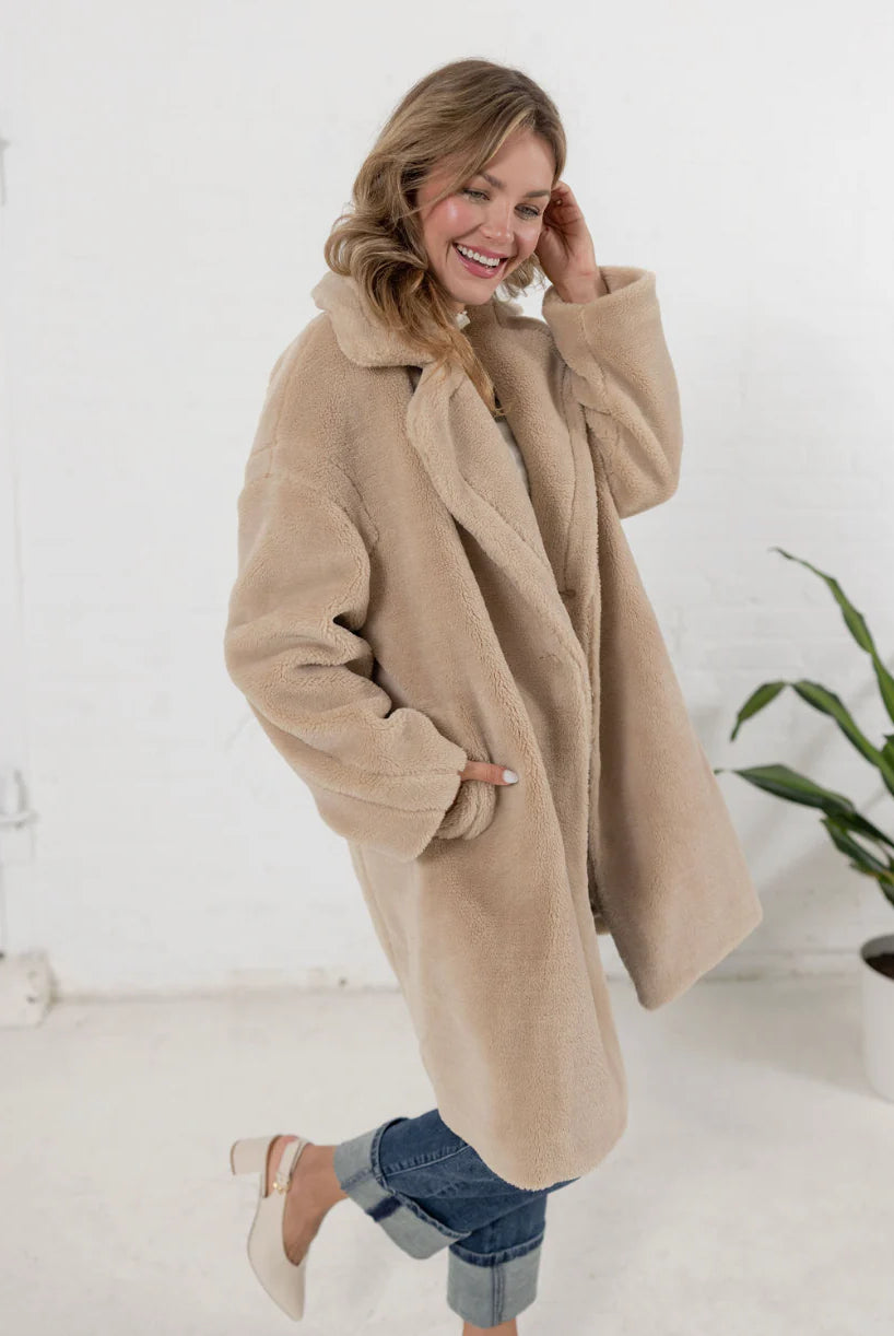 woman wearing a plush teddy coat in an oatmeal color from Mainstream Boutique Bloomington