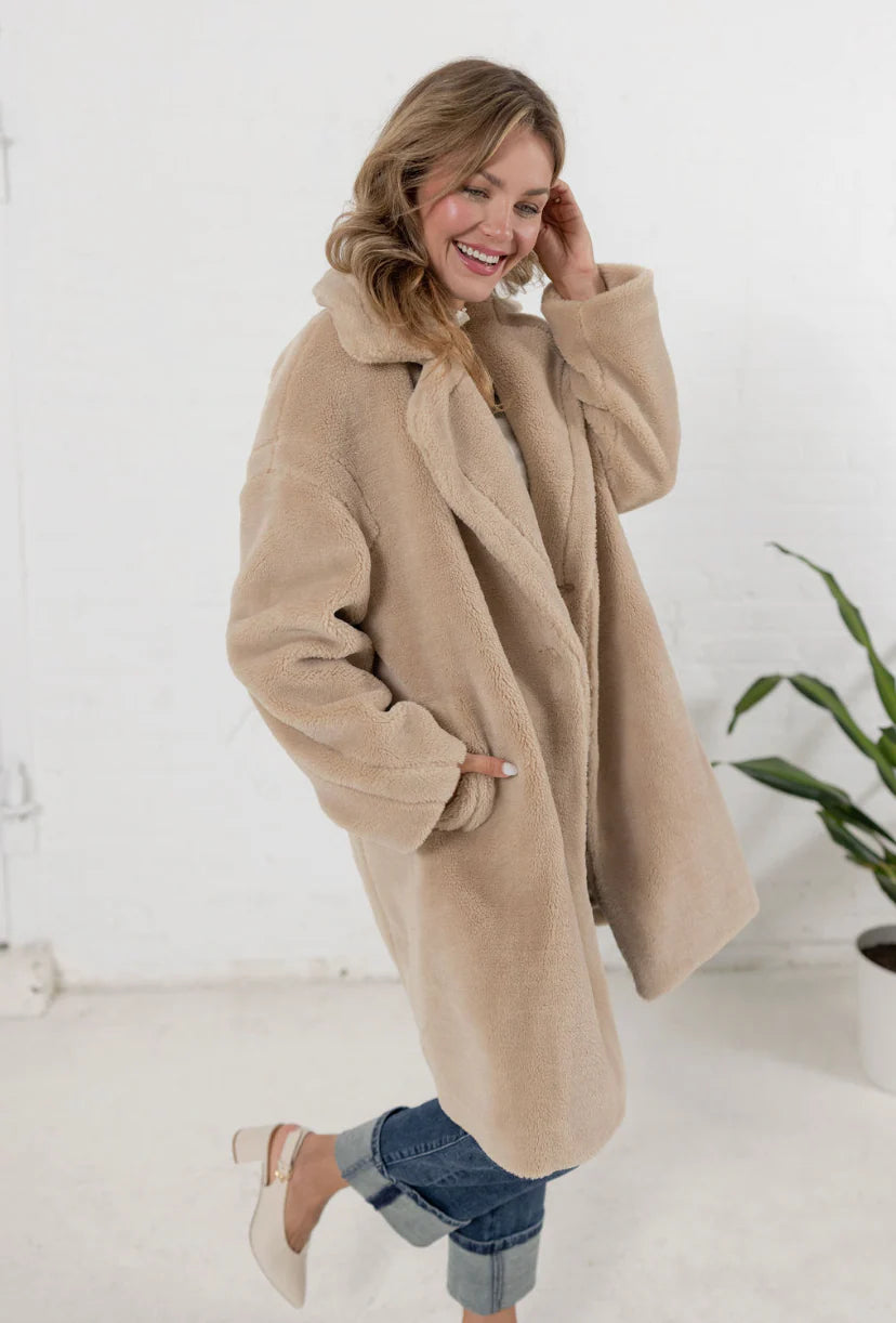woman wearing a plush teddy coat in an oatmeal color from Mainstream Boutique Bloomington