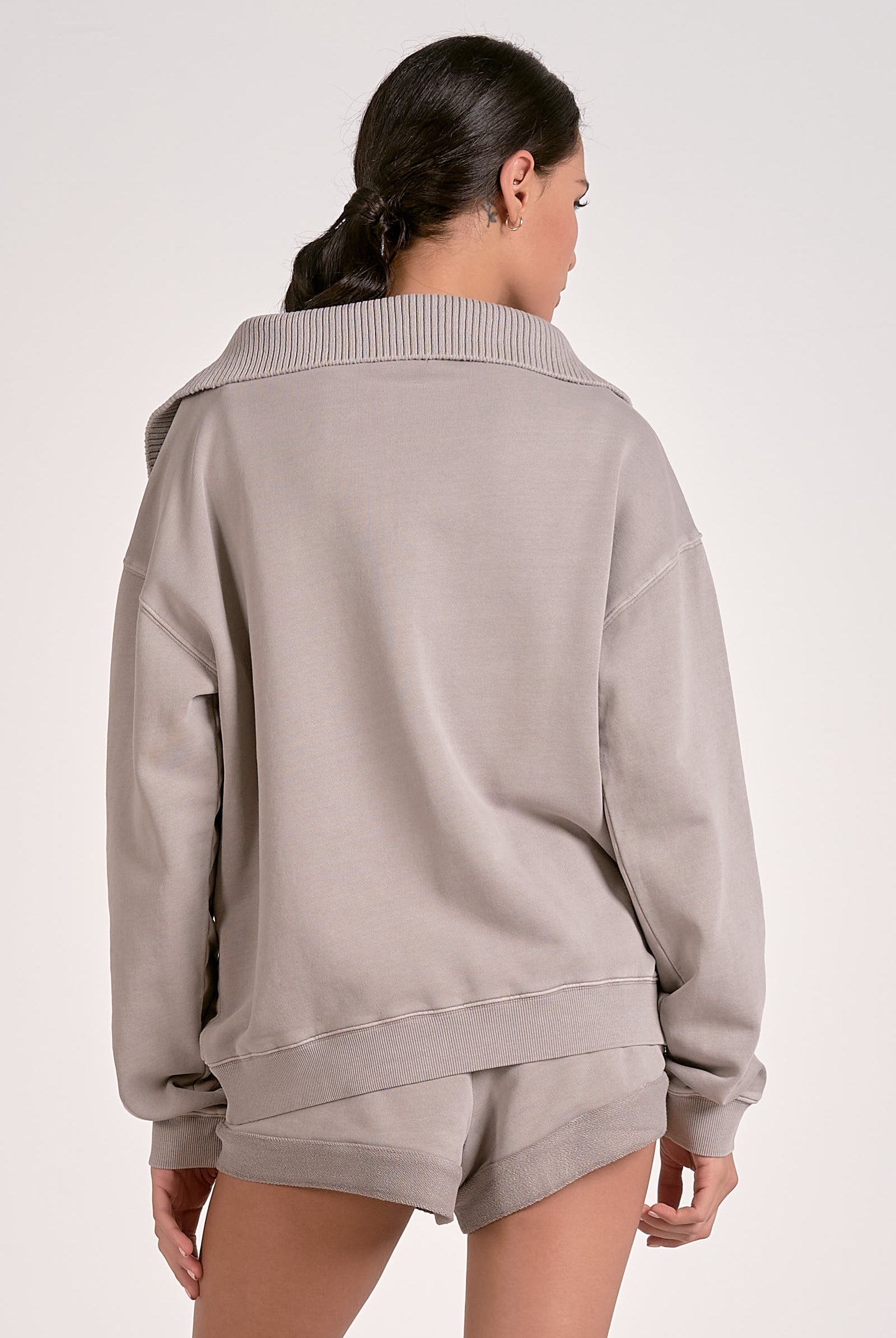 Model showing the back of the heather gray quarter zip ribbed sweatshirt