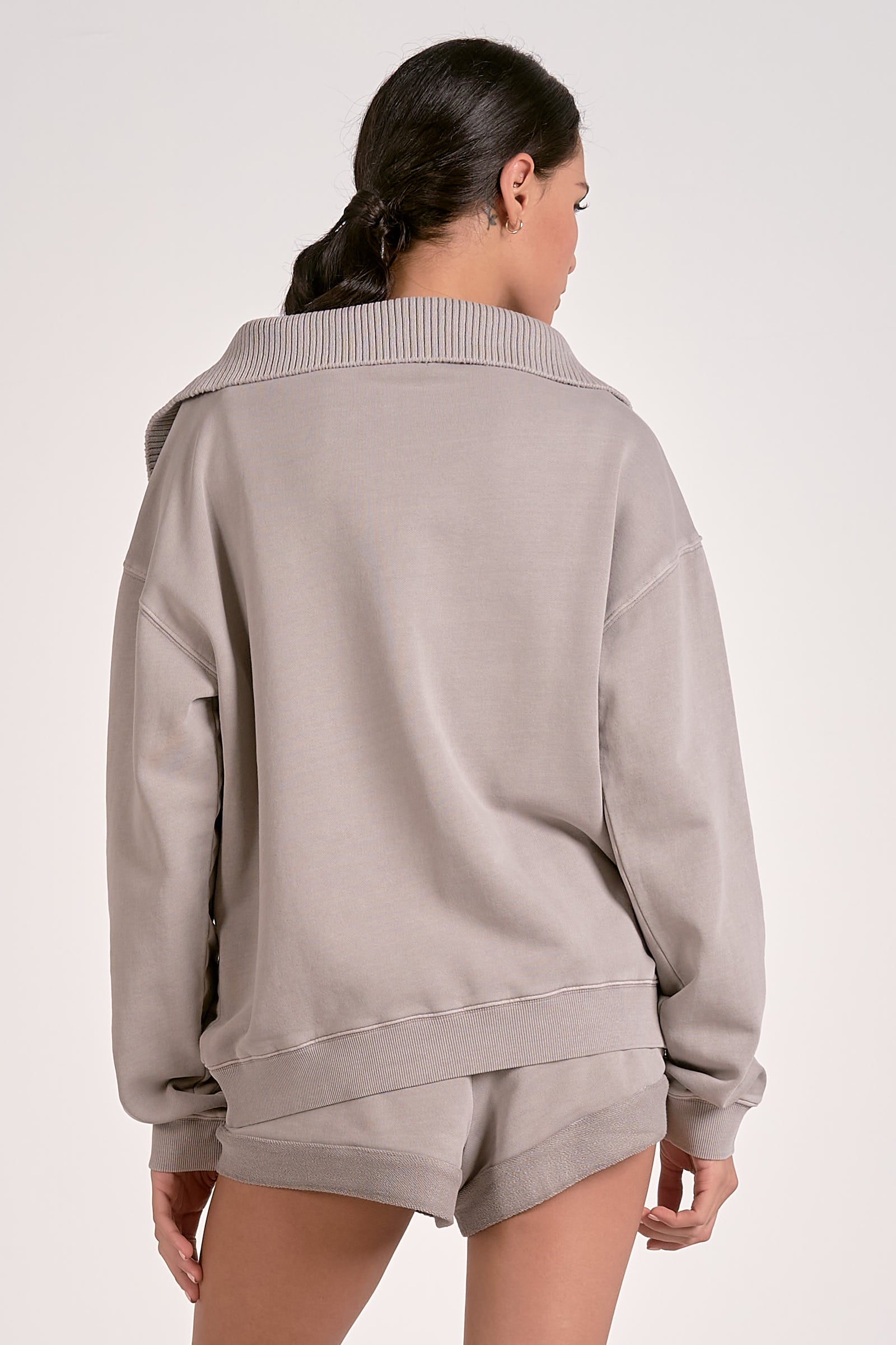 Model showing the back of the heather gray quarter zip ribbed sweatshirt