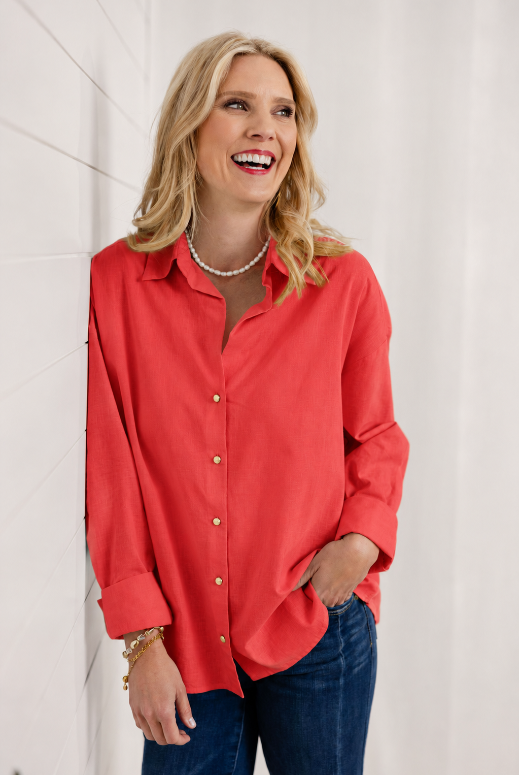 woman wearing red button down gold button detailed top