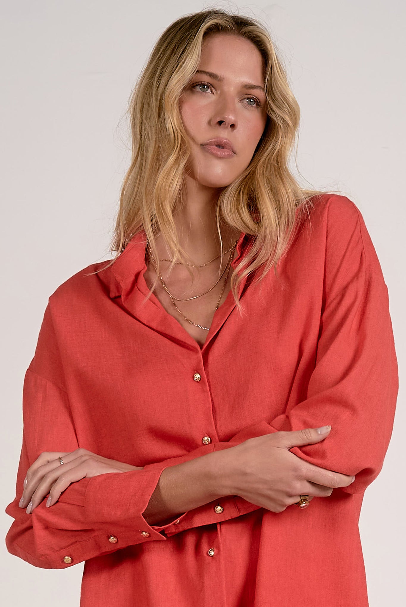 woman wearing red button down long sleeve top with gold buttons