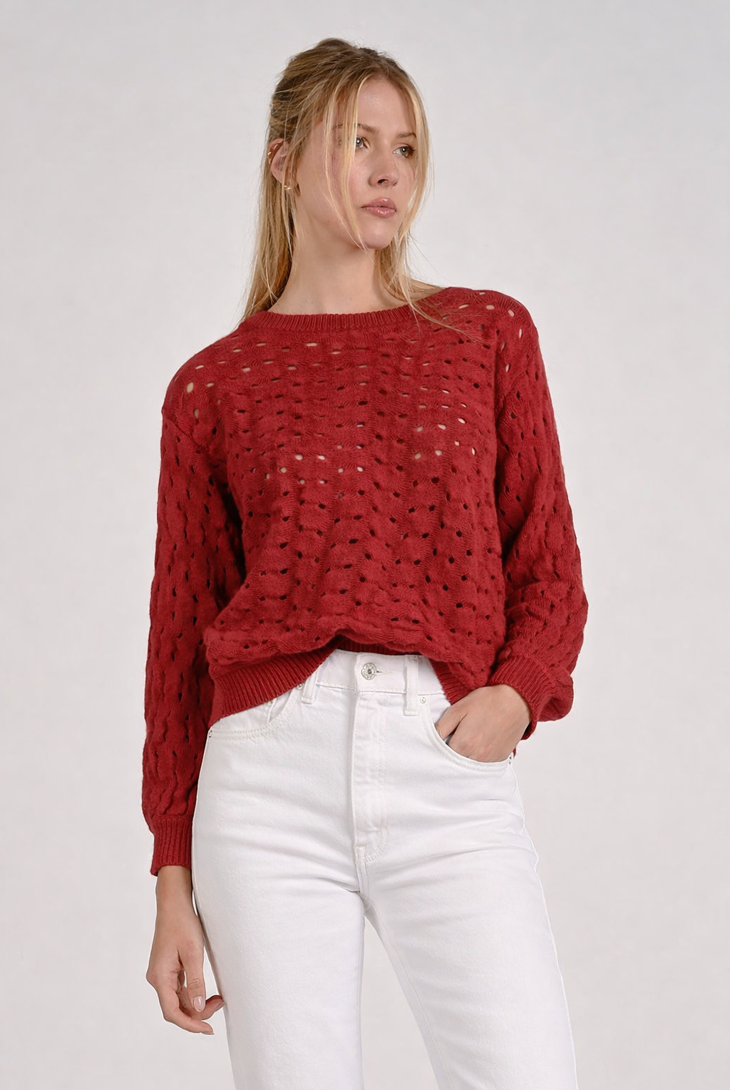 Red open stitch knit sweater with textured lightweight knit shown wearing it on both shoulders