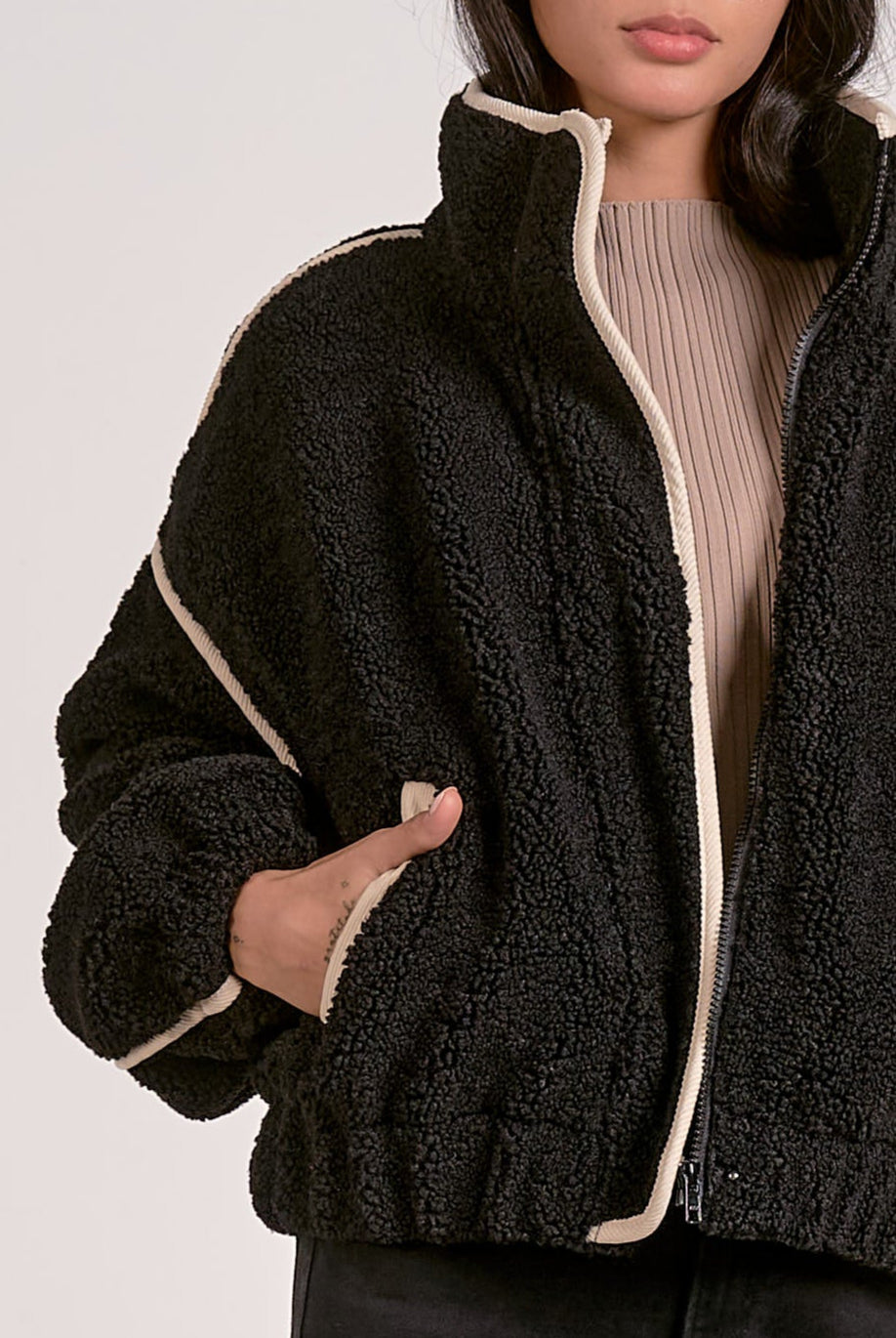 woman wearing a black sherpa bomber jacket with contrast trim