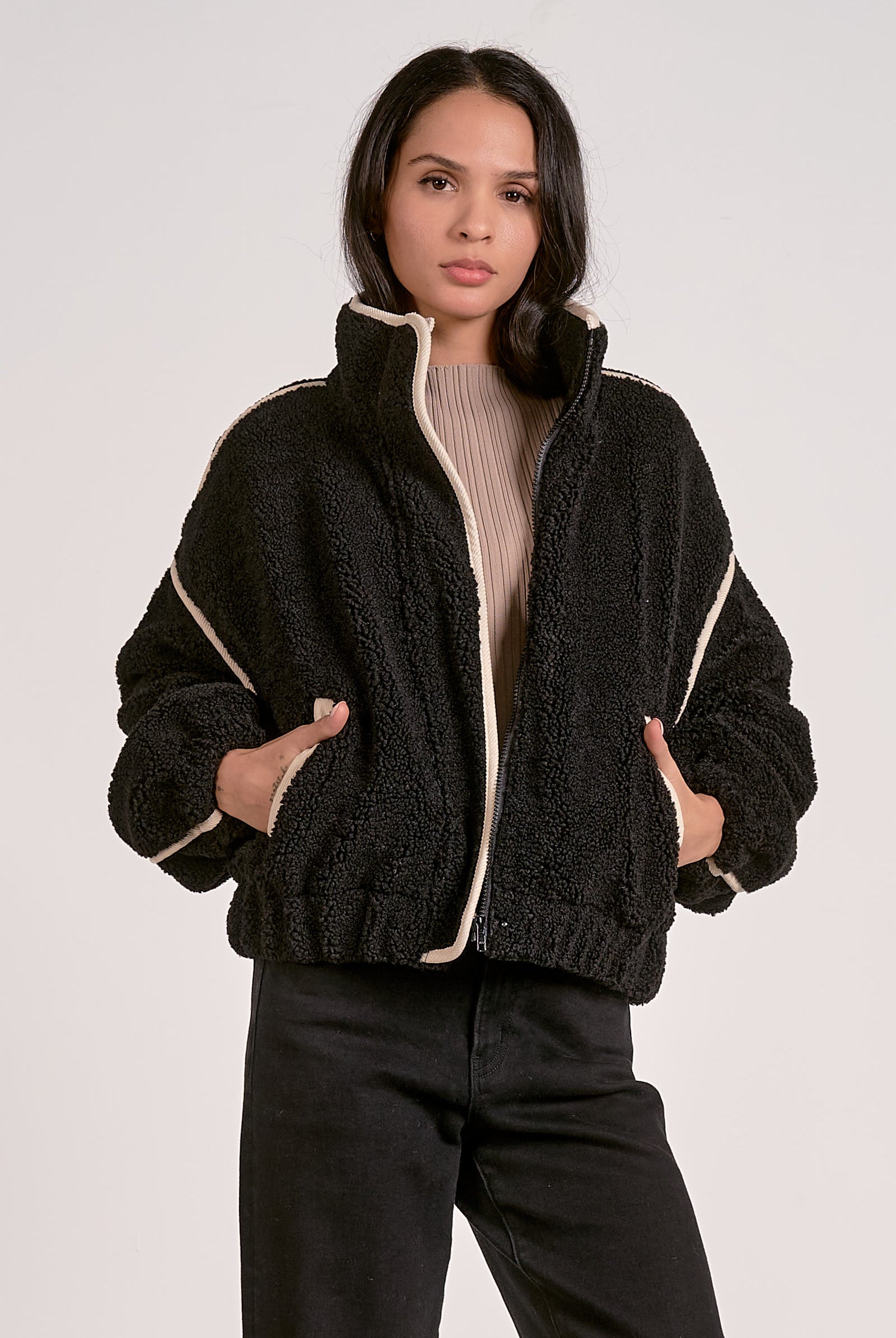woman wearing a black sherpa bomber jacket with contrast trim