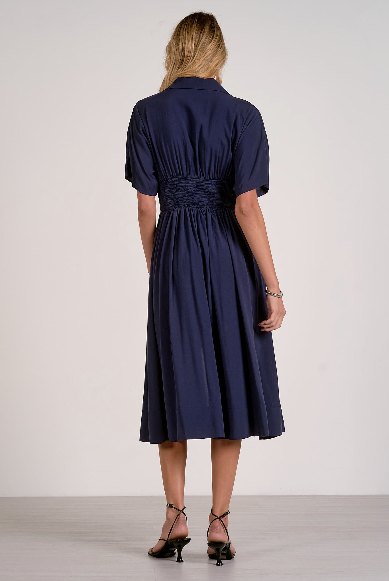 back view of navy smocked waist midi dress showing comfortable drape