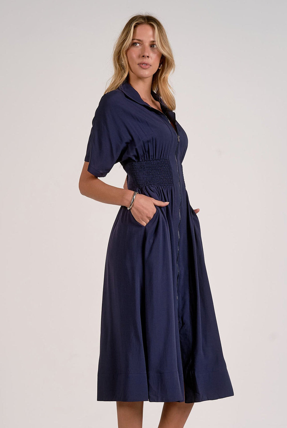 side view of navy smocked waist midi dress with relaxed skirt and flattering waist detail