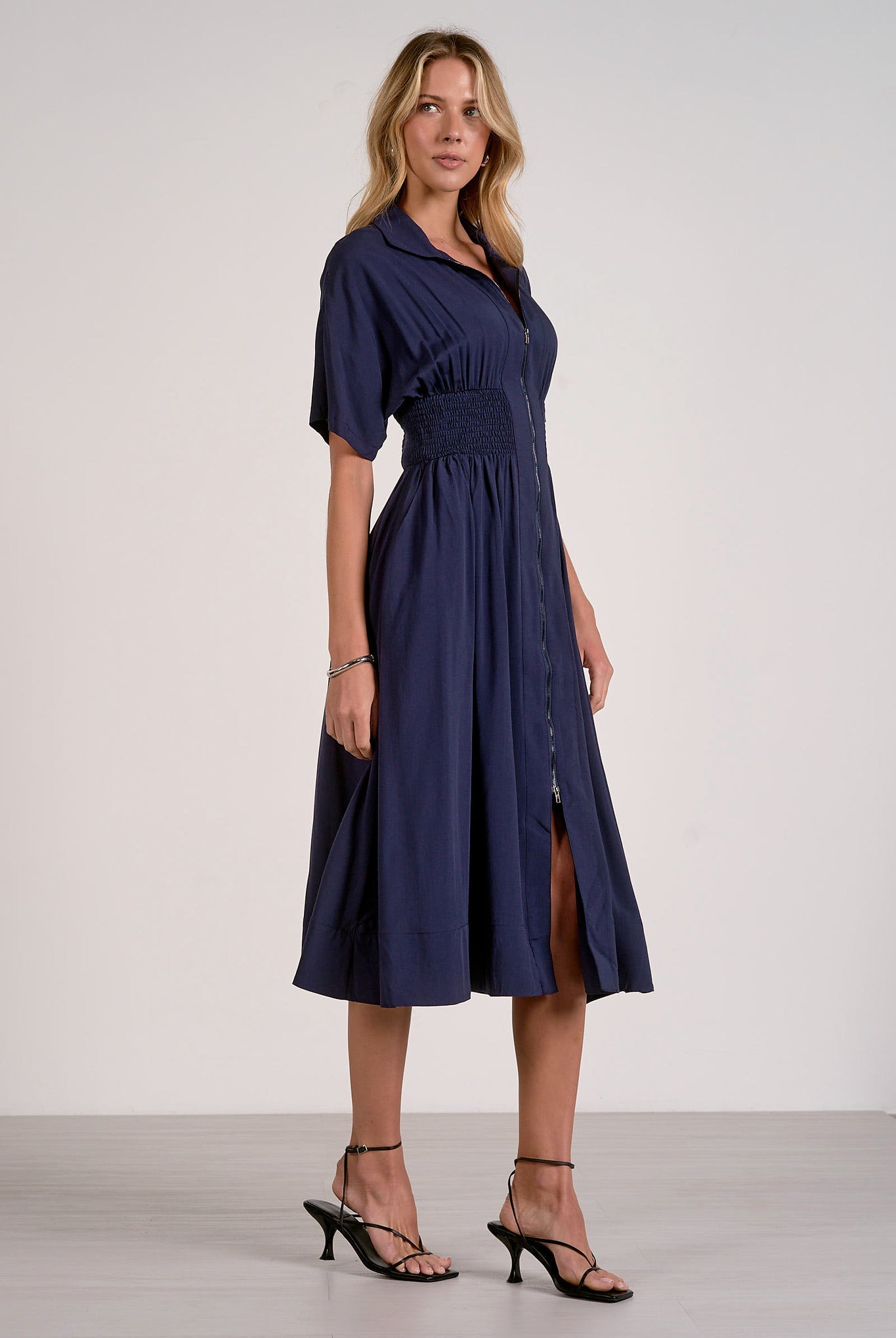 Side view of navy smocked waist midi dress showing comfortable drape