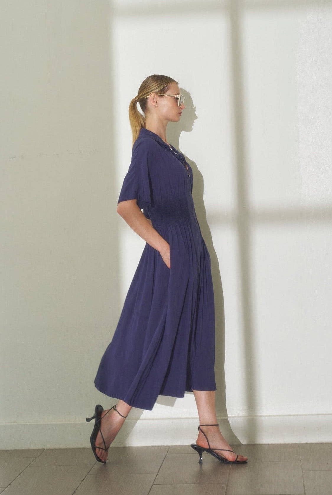 lifestyle photo of navy smocked waist midi dress showing comfortable drape