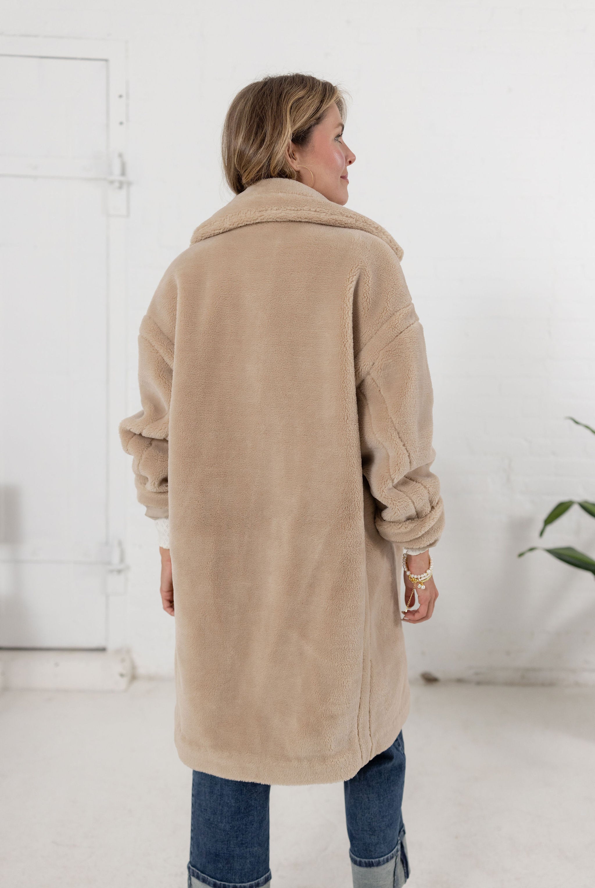woman showing the back of the plush teddy coat from Mainstream Boutique Bloomington